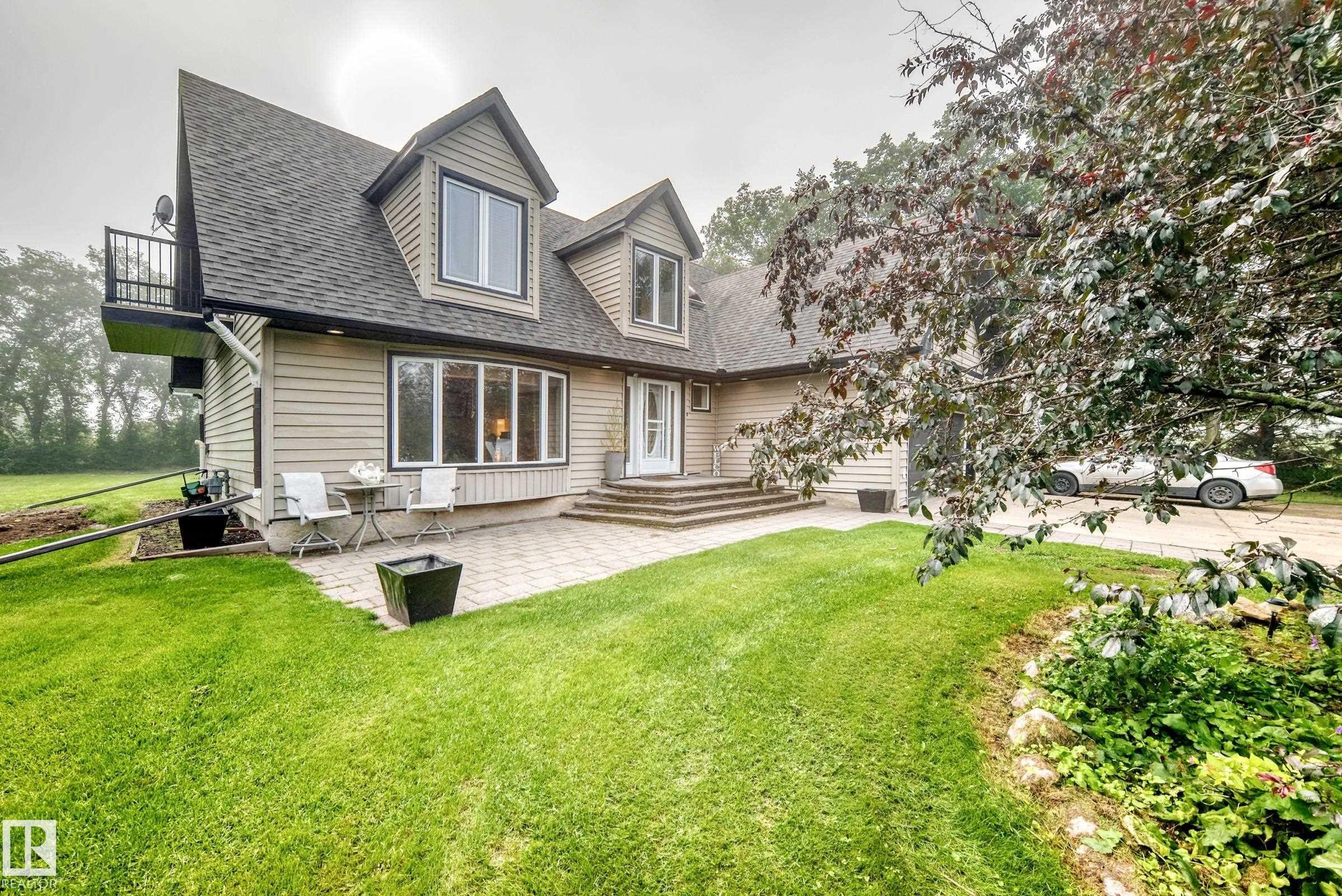 Siding exterior with multiple dormers, a bay window, and an upper-level balcony - #38 24512 Sturgeon Rd, Rural Sturgeon County, AB