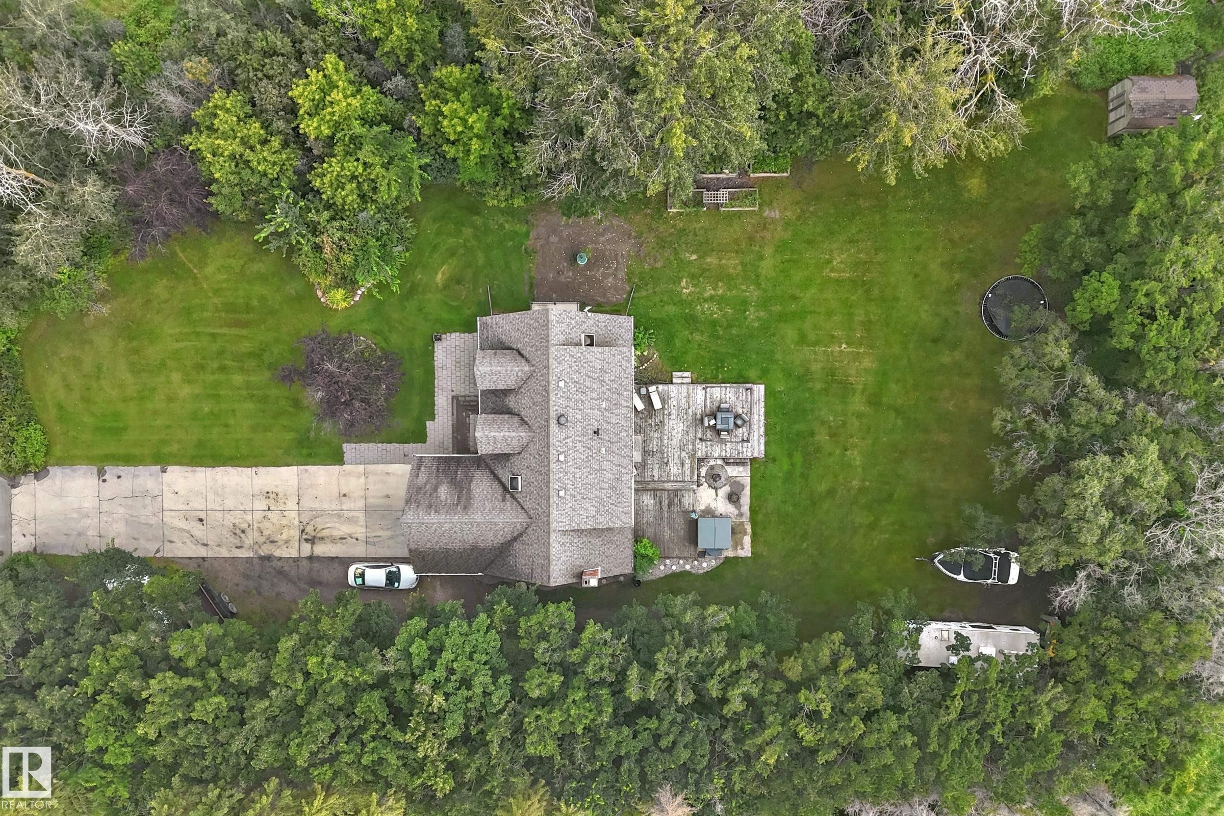 Expansive lot featuring a multi-level roofline, extensive concrete driveway, and a spacious rear deck - #38 24512 Sturgeon Rd, Rural Sturgeon County, AB