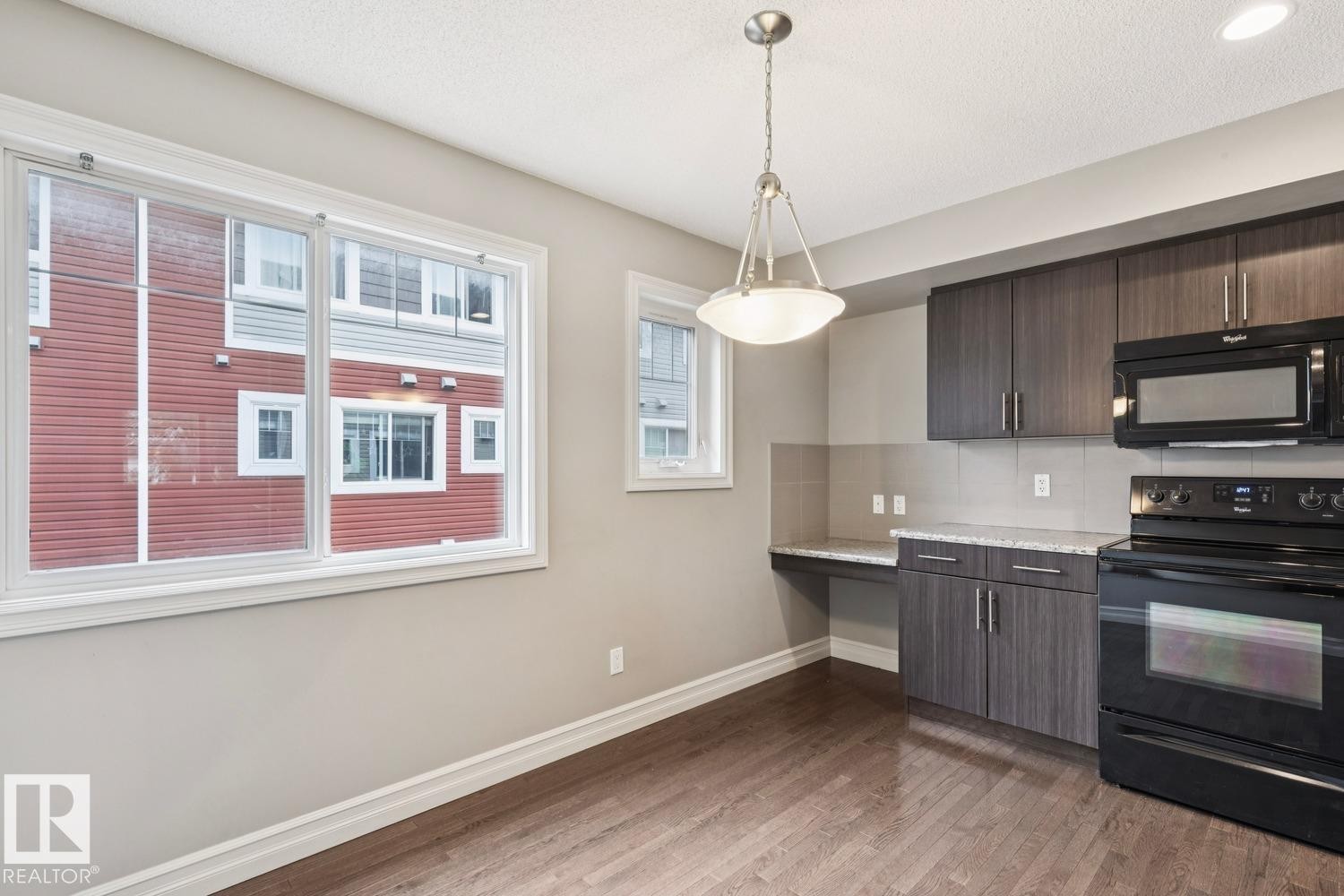 Wood-finish flooring, recessed ceiling lighting, pendant light fixture, built-in cabinetry, and integrated countertop space - 5409 3 Avenue Sw, Edmonton, AB - Indoor Photo Showing Kitchen