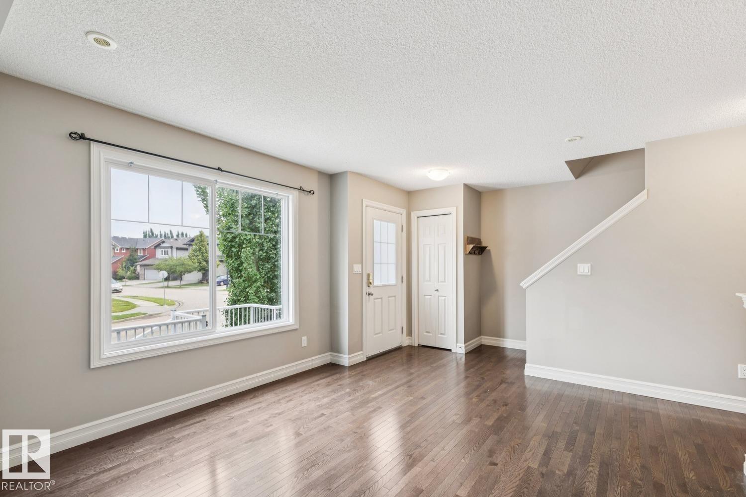 Hardwood-finish flooring, recessed ceiling lighting, window with grid panes, white trim, and a white interior door - 5409 3 Avenue Sw, Edmonton, AB - Indoor Photo Showing Other Room
