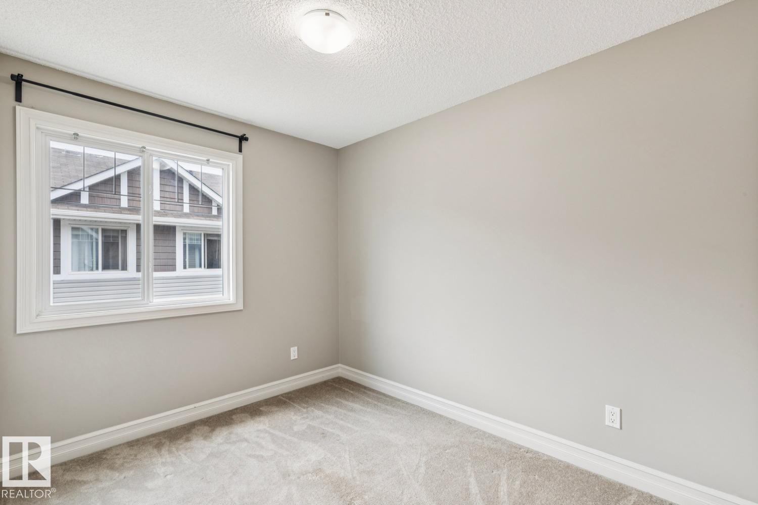 Wall-to-wall carpeting, neutral wall paint, white trim, single window, and a ceiling-mounted light fixture - 5409 3 Avenue Sw, Edmonton, AB - Indoor Photo Showing Other Room