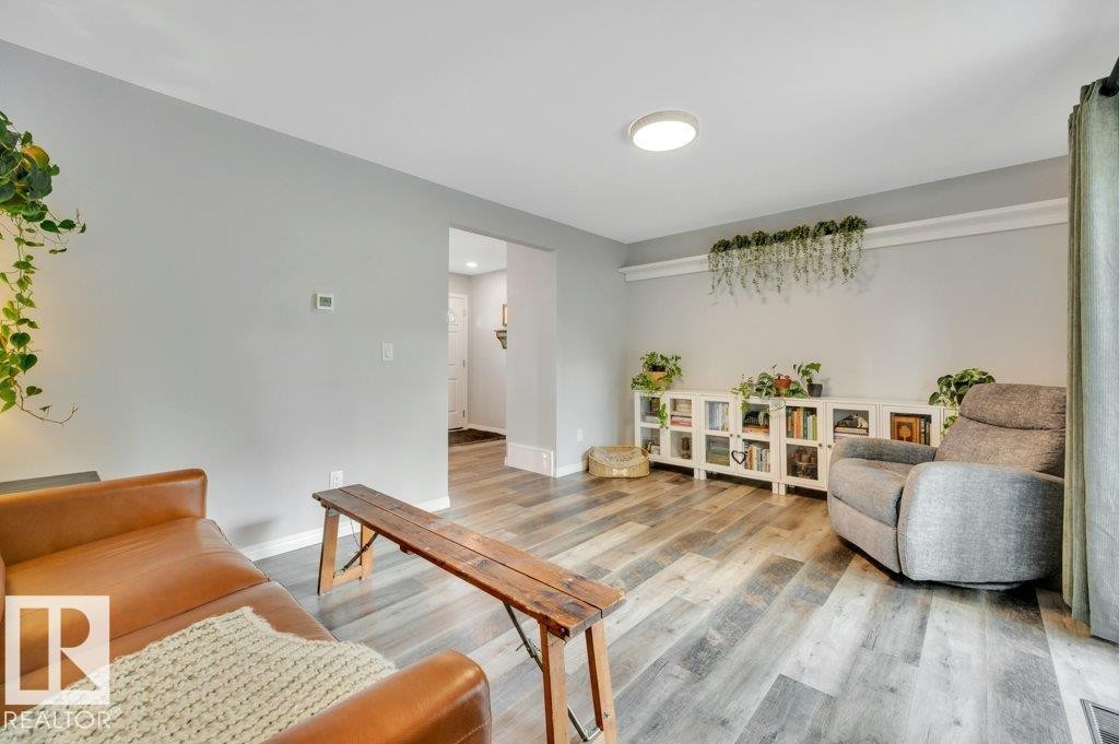 Vinyl plank flooring throughout, complemented by a built-in white storage console - #138 5231 51 St, Bon Accord, AB - Indoor Photo Showing Living Room