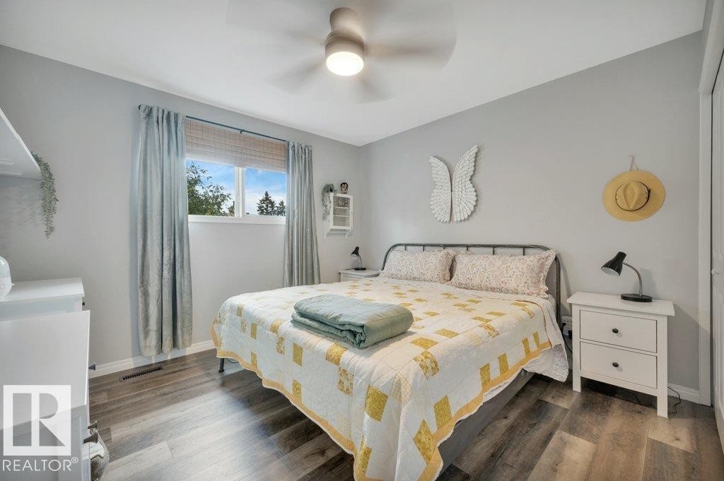 Vinyl Plank flooring, window with natural light, ceiling fan with integrated lighting, built-in shelving, and white interior doors - #138 5231 51 St, Bon Accord, AB - Indoor Photo Showing Bedroom