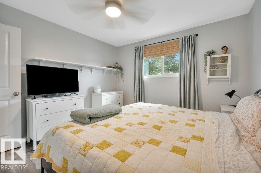 Vinyl Plank flooring with a white door and modern ceiling fan - #138 5231 51 St, Bon Accord, AB - Indoor Photo Showing Bedroom