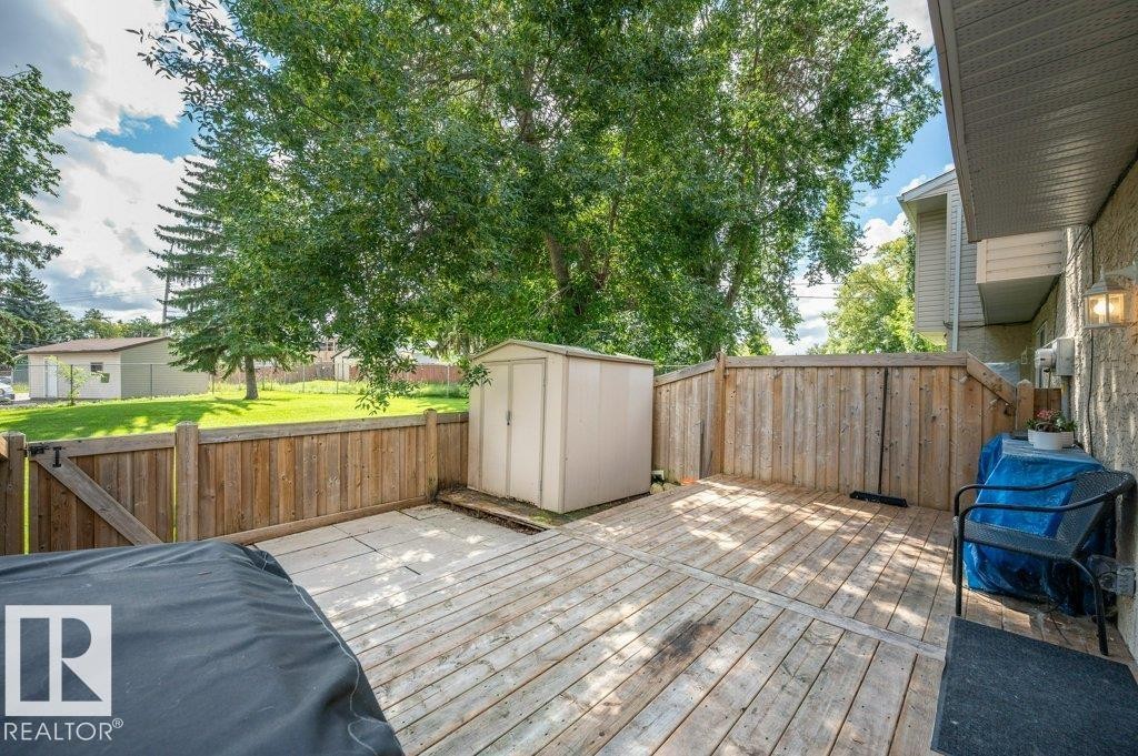 Wood-finish deck with privacy fencing, a storage shed, and exterior wall lighting - #138 5231 51 St, Bon Accord, AB - Outdoor With Deck Patio Veranda With Exterior