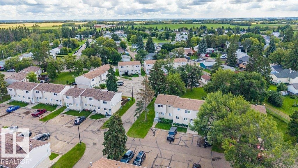 Townhome residences with individual parking spaces, surrounded by mature trees, and land - #138 5231 51 St, Bon Accord, AB - Outdoor With View