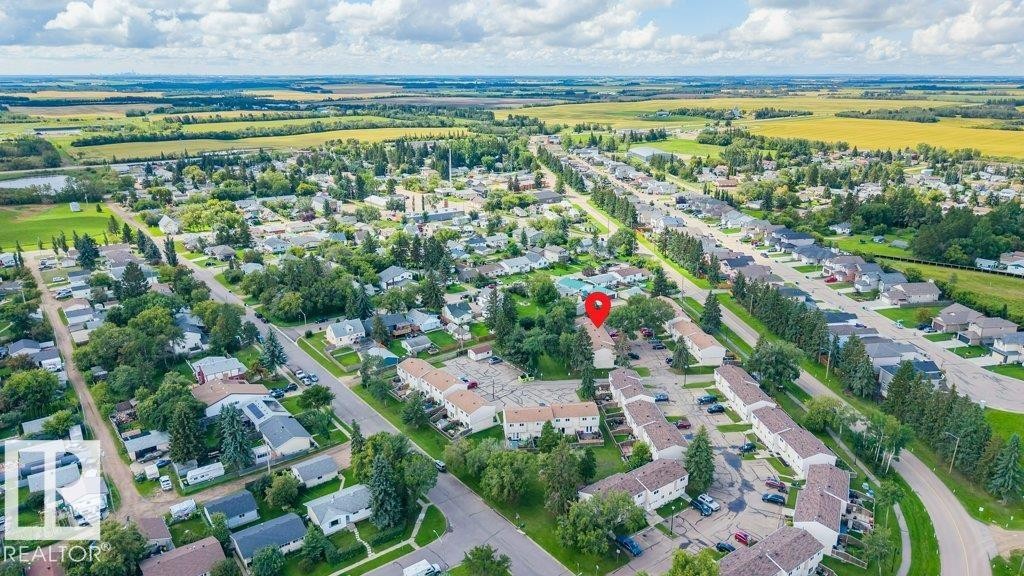 Aerial perspective showcasing a residential community with abundant mature trees and expansive green spaces - #138 5231 51 St, Bon Accord, AB - Outdoor With View