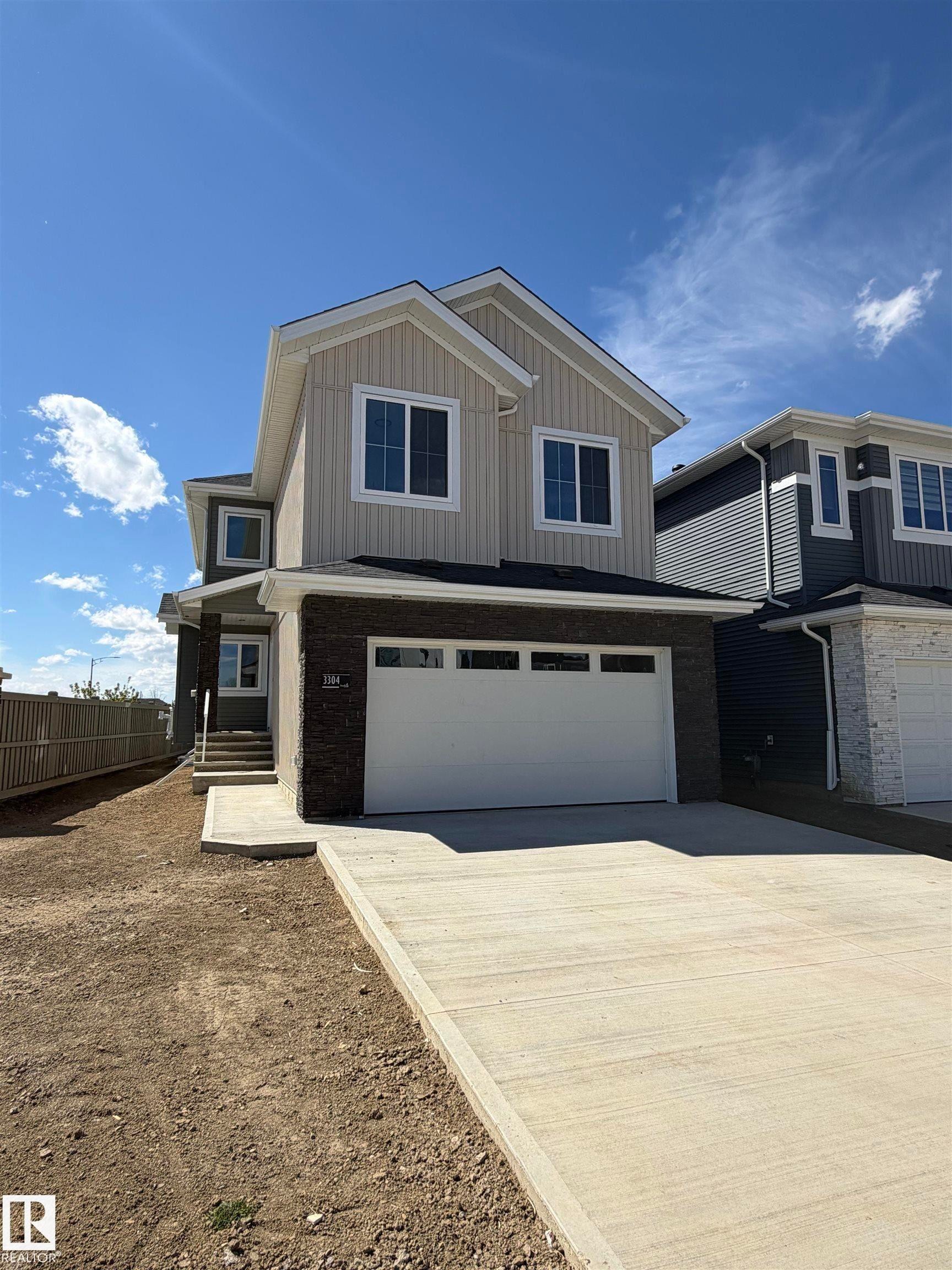 Modern construction featuring an attached garage, concrete driveway, and front walkway - 3304 Chickadee Drive Nw, Edmonton, AB - Outdoor With Facade