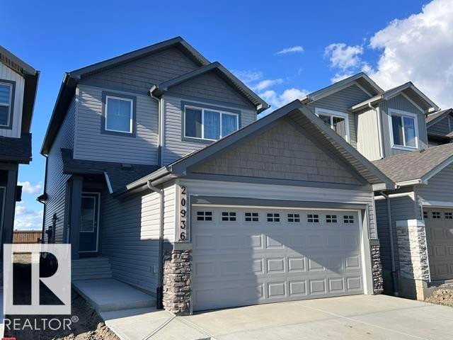 Two-story exterior with multi-toned siding, stone accents, attached garage, and concrete walkway - 20936 16 Avenue Nw, Edmonton, AB - Outdoor