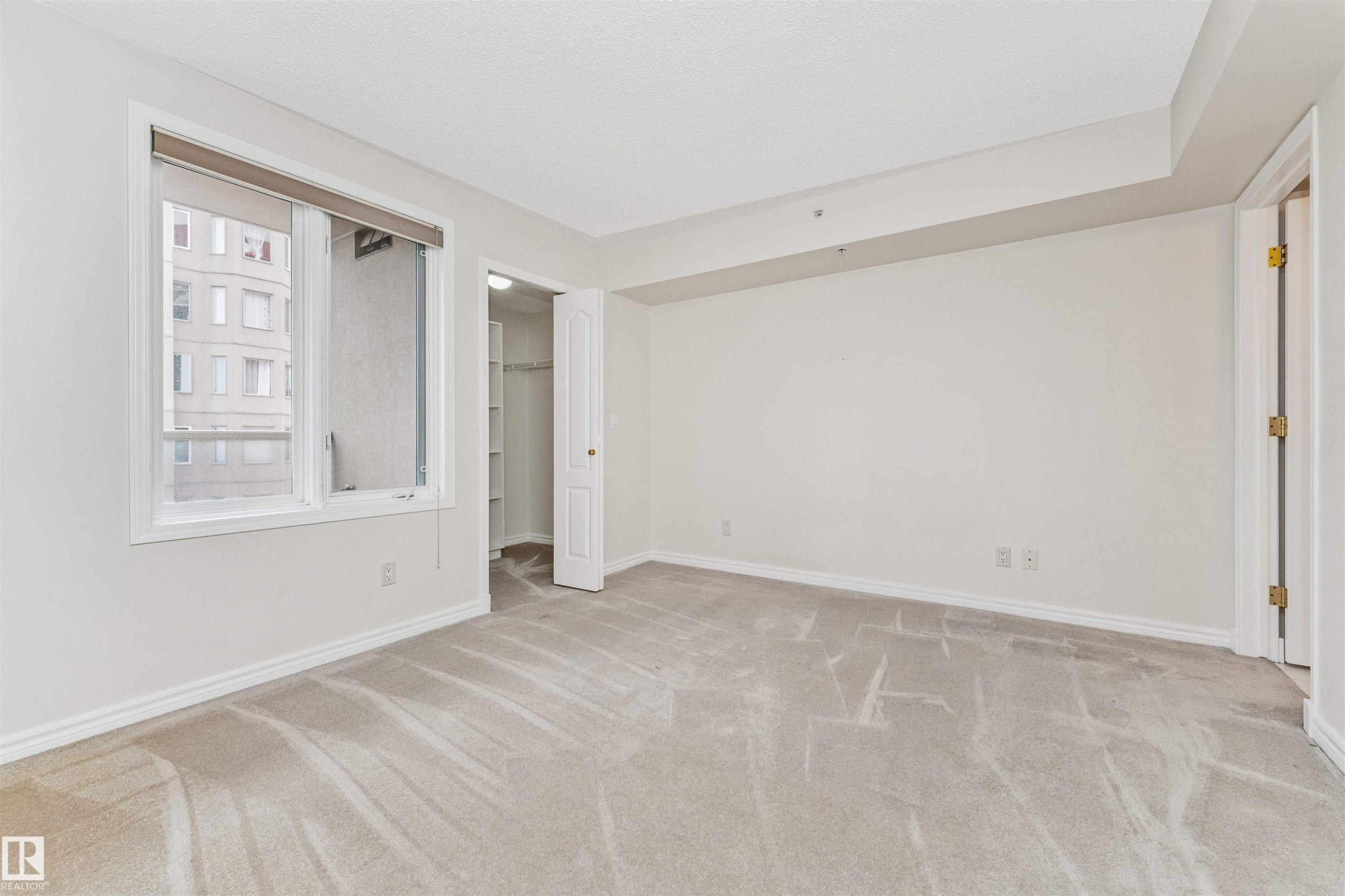 Bright room with light-toned carpeting, white walls, and a large window - #1101 10909 103 Av Nw, Edmonton, AB - Indoor Photo Showing Other Room