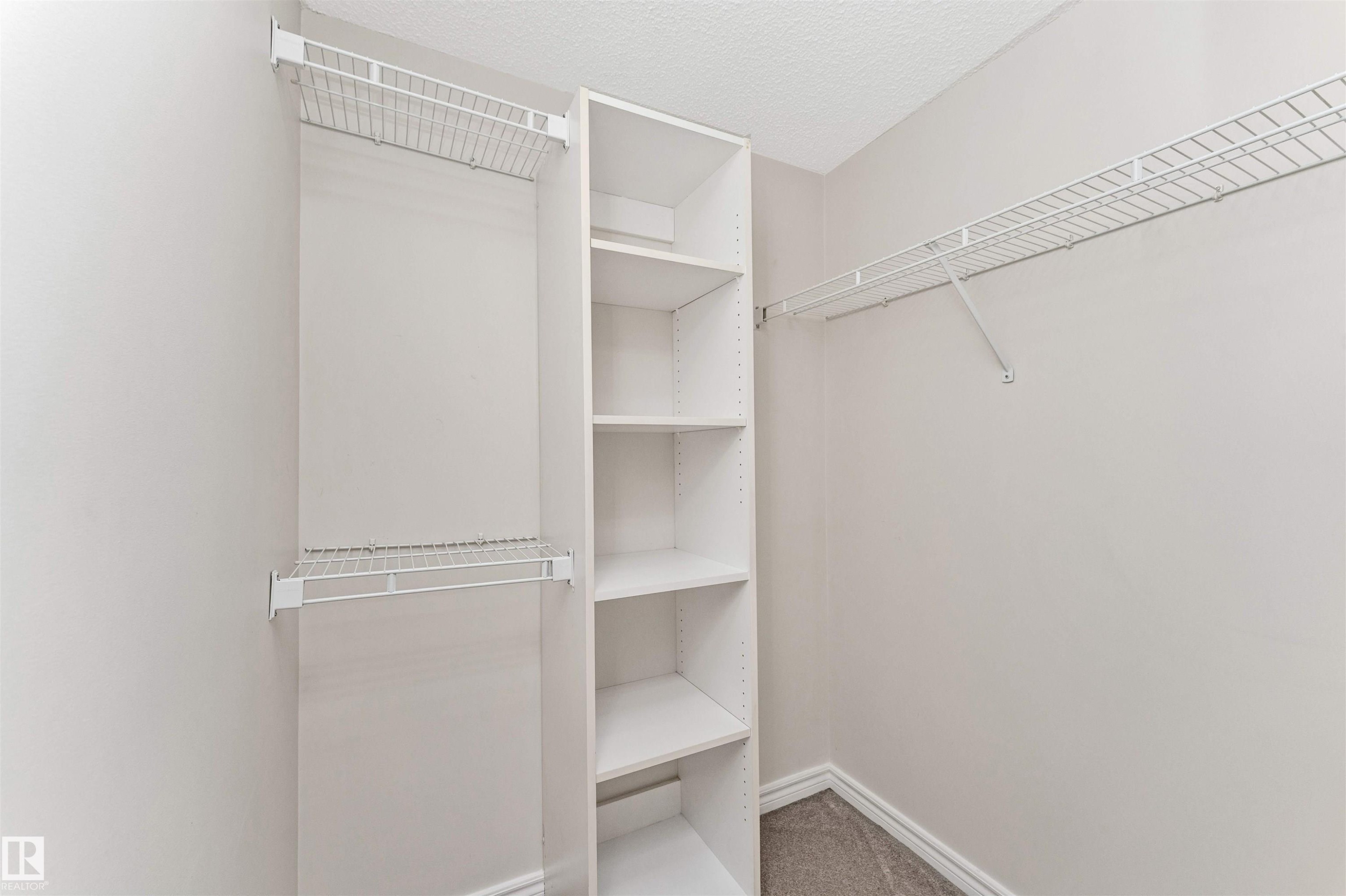 Walk-in closet featuring built-in shelving units and wire rack storage - #1101 10909 103 Av Nw, Edmonton, AB - Indoor With Storage