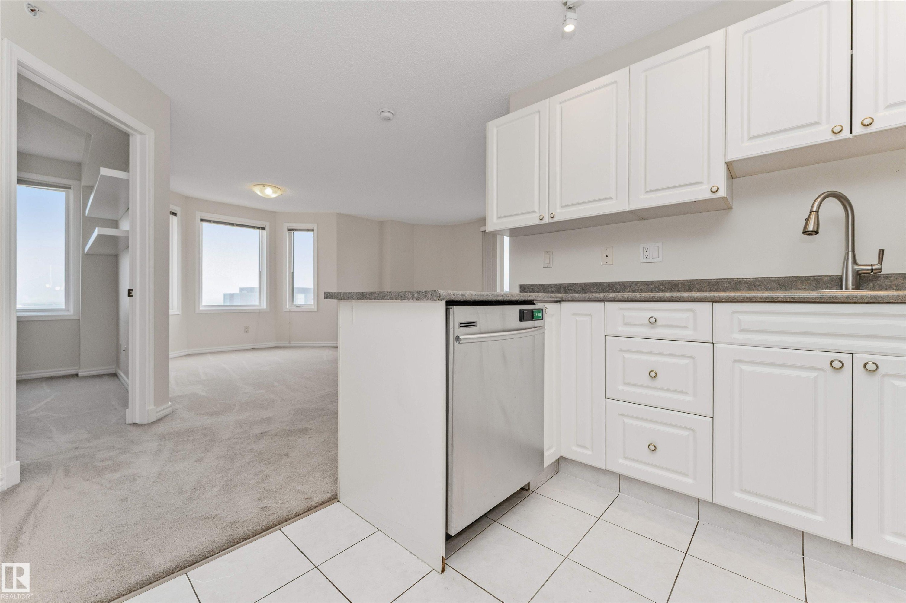 Kitchen featuring white cabinetry, stainless steel dishwasher, and a gooseneck faucet - #1101 10909 103 Av Nw, Edmonton, AB - Indoor Photo Showing Kitchen