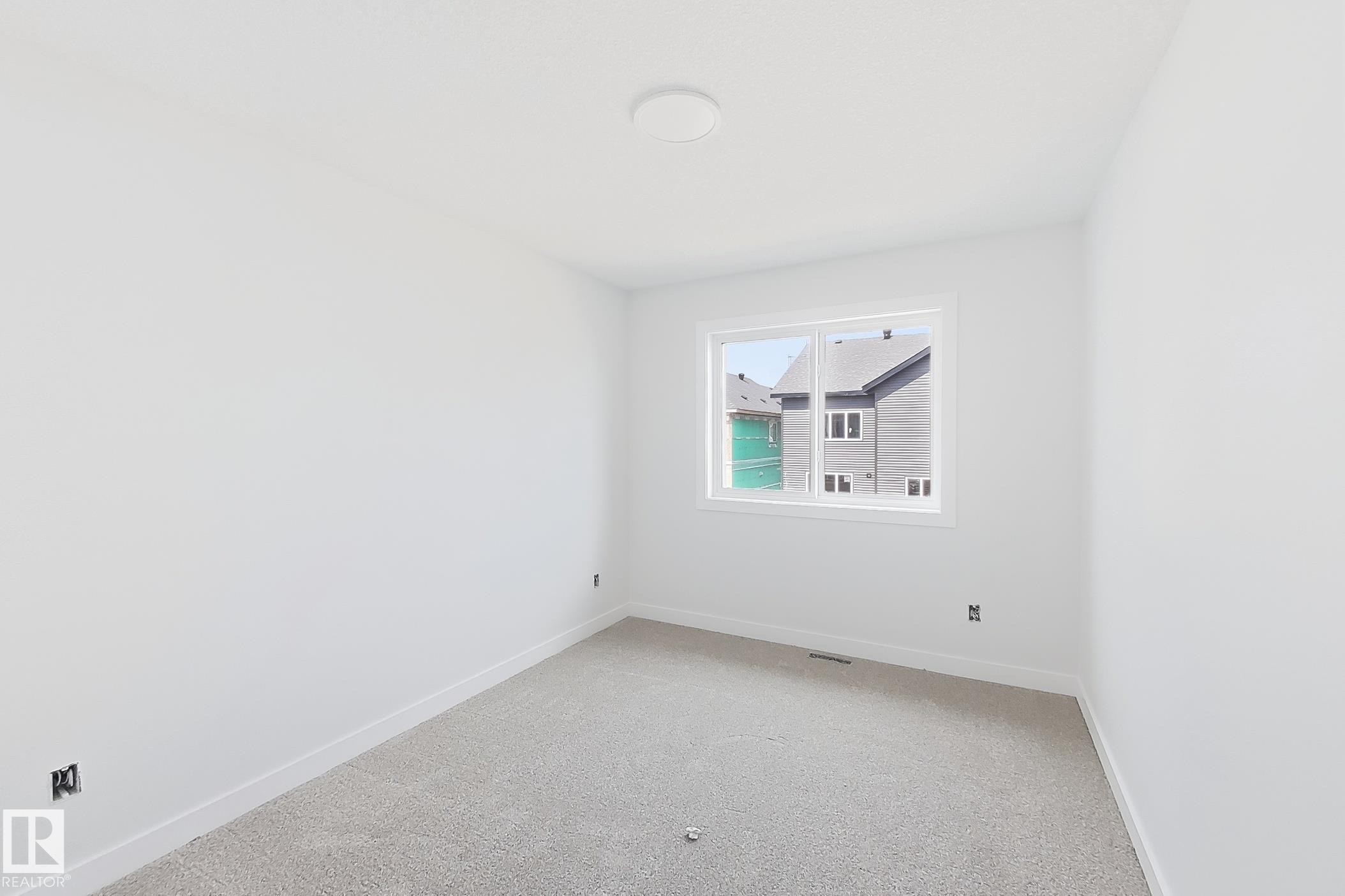 Window with white trim, wall-to-wall carpeting, white walls, and a ceiling-mounted light fixture - 13118 186 Avenue Nw, Edmonton, AB - Indoor Photo Showing Other Room
