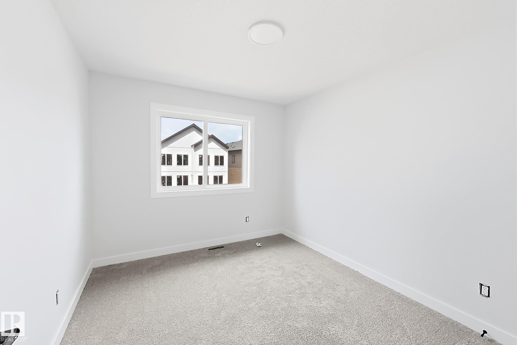 Neutral wall paint throughout, light-toned carpeting, ample natural light from a double-pane window, and a flush-mount ceiling light - 13118 186 Avenue Nw, Edmonton, AB - Indoor Photo Showing Other Room