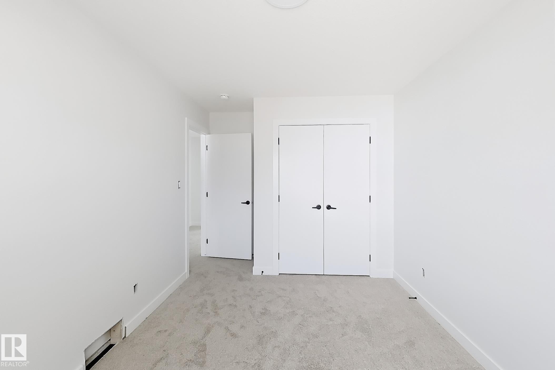 Neutral color palette with light-toned carpeting and bright white walls - 13118 186 Avenue Nw, Edmonton, AB - Indoor Photo Showing Other Room