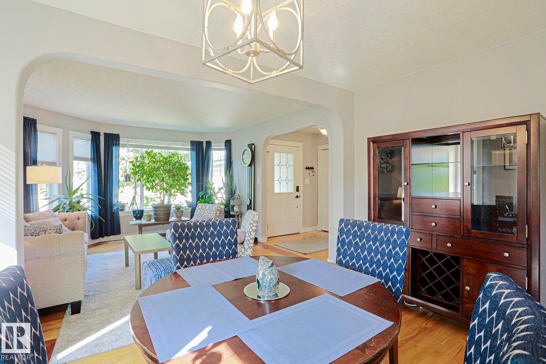 Hardwood-finish flooring throughout, featuring a curved bay window, arched doorway, and a built-in display cabinet - 12 Douziech Close, St. Albert, AB - Indoor
