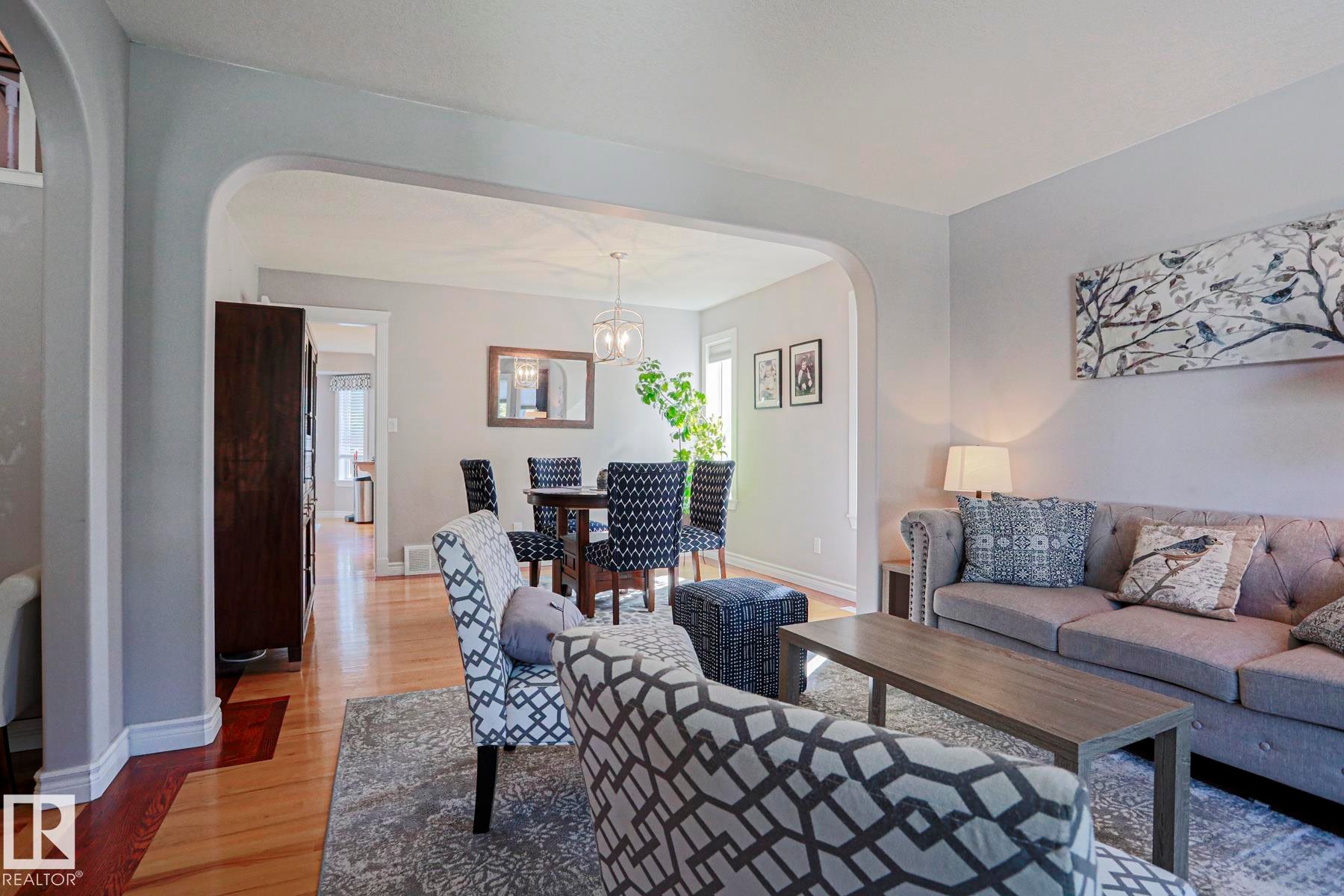 Archway entry, wood-finish flooring, recessed lighting, and a contemporary pendant light fixture - 12 Douziech Close, St. Albert, AB - Indoor Photo Showing Living Room