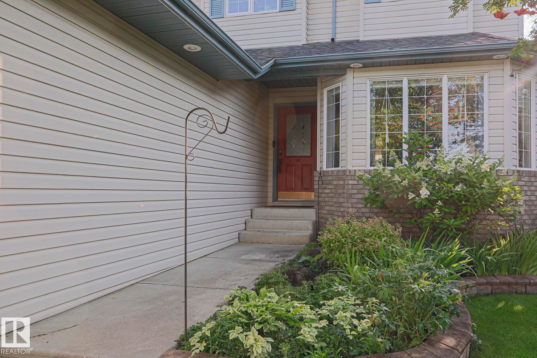 Light-colored siding exterior with a red front door - 12 Douziech Close, St. Albert, AB - Outdoor