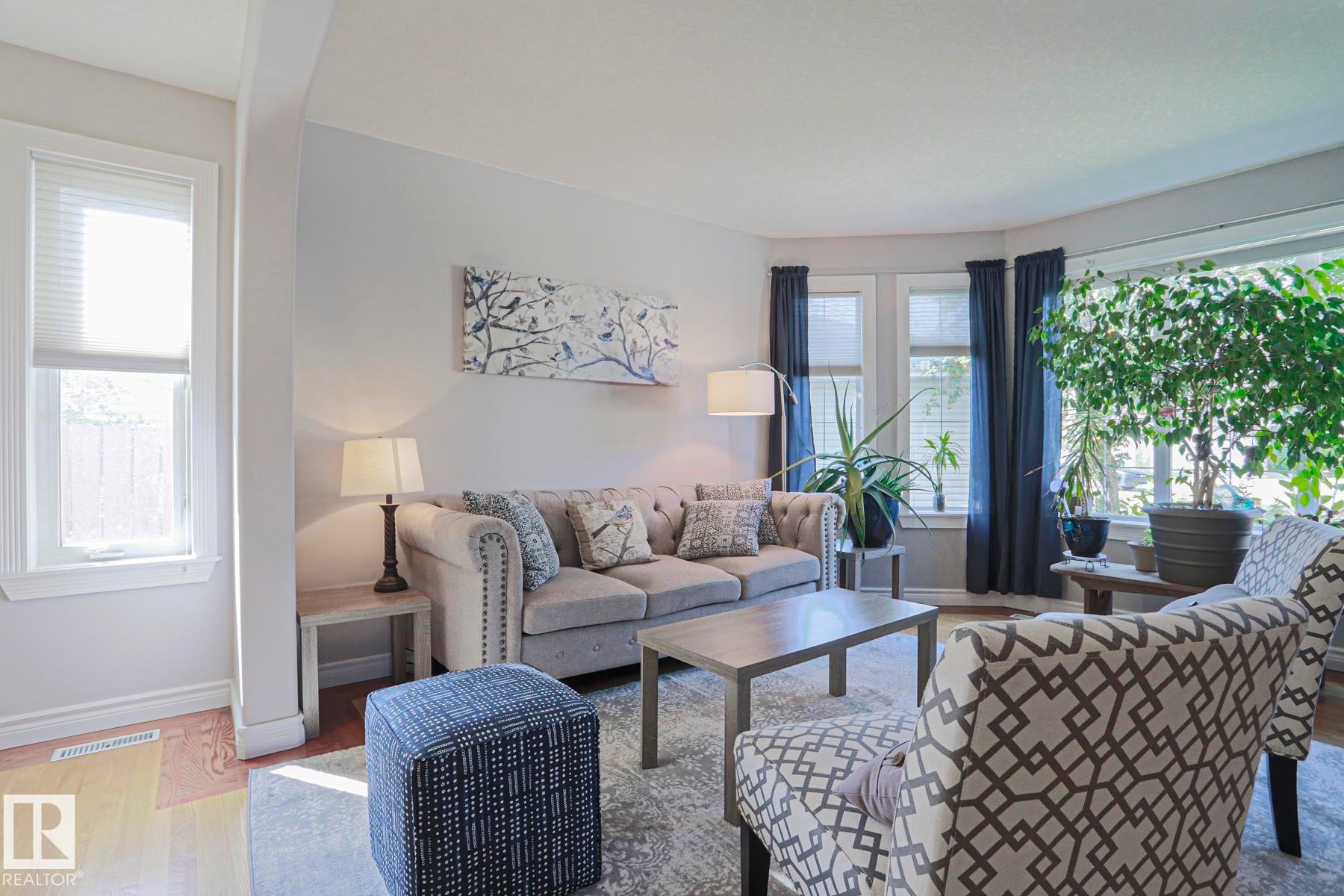 Hardwood flooring, light gray wall color, multiple windows, large bay window, and recessed lighting - 12 Douziech Close, St. Albert, AB - Indoor Photo Showing Living Room