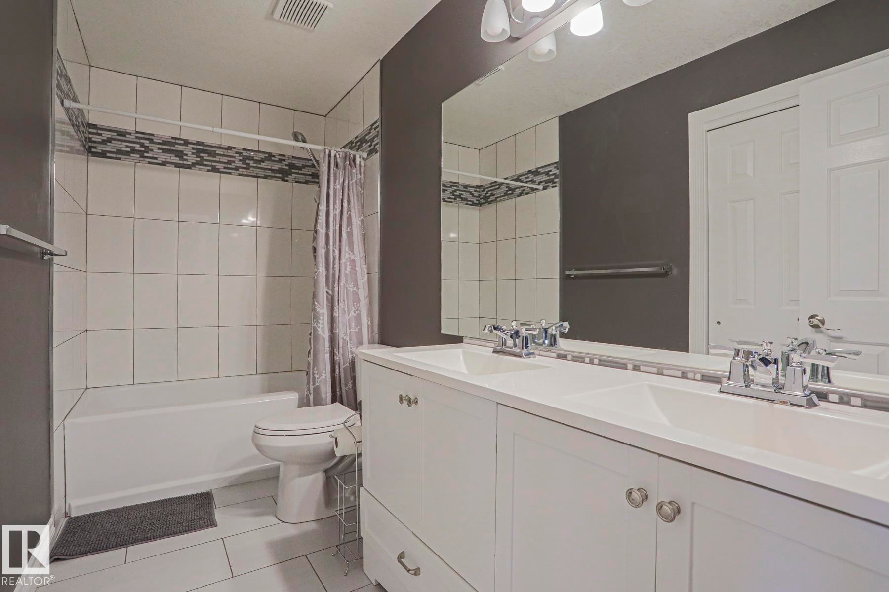 Double vanity with integrated sinks, chrome faucets, and white cabinetry - 12 Douziech Close, St. Albert, AB - Indoor Photo Showing Bathroom