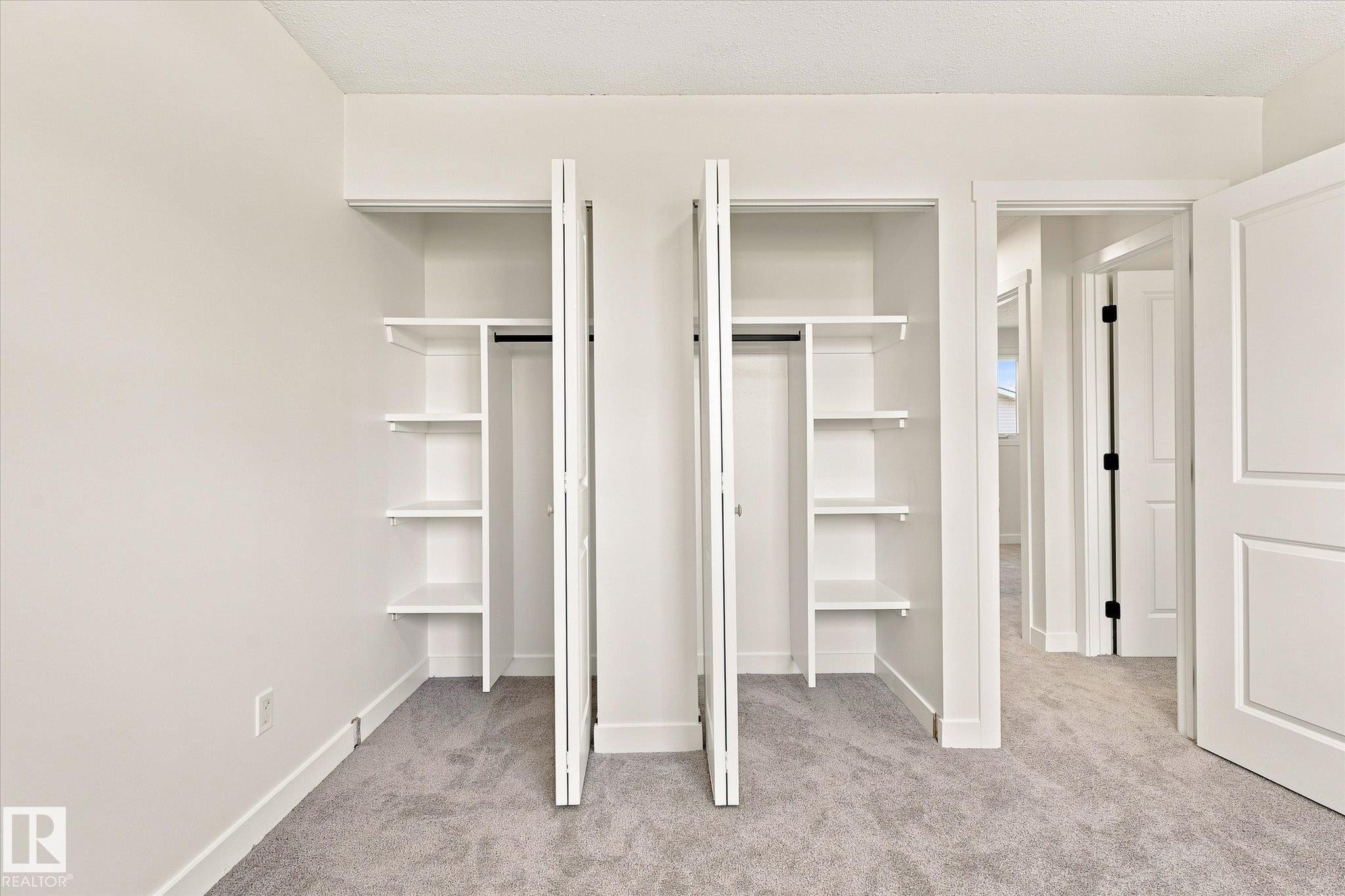 Dual custom built-in closets featuring integrated shelving and hanging rods - 18307 66 Avenue Nw, Edmonton, AB - Indoor Photo Showing Other Room