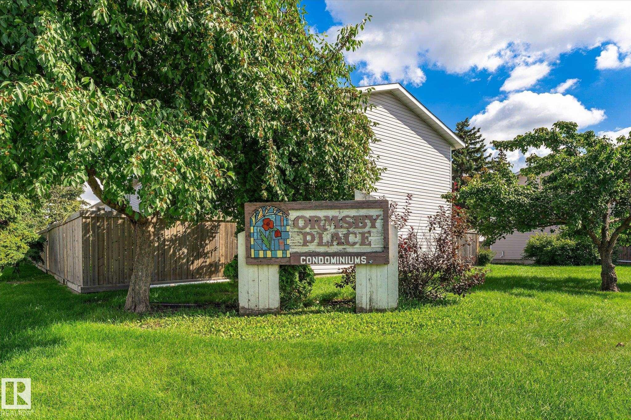 Manicured lawn with mature trees and wood fencing - 18307 66 Avenue Nw, Edmonton, AB - Outdoor