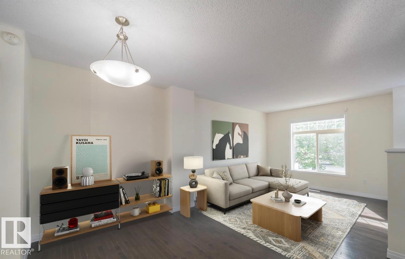 Expansive living area with dark wood-finish flooring, a large window, and a contemporary ceiling light fixture - #66 465 Hemingway Rd Nw, Edmonton, AB