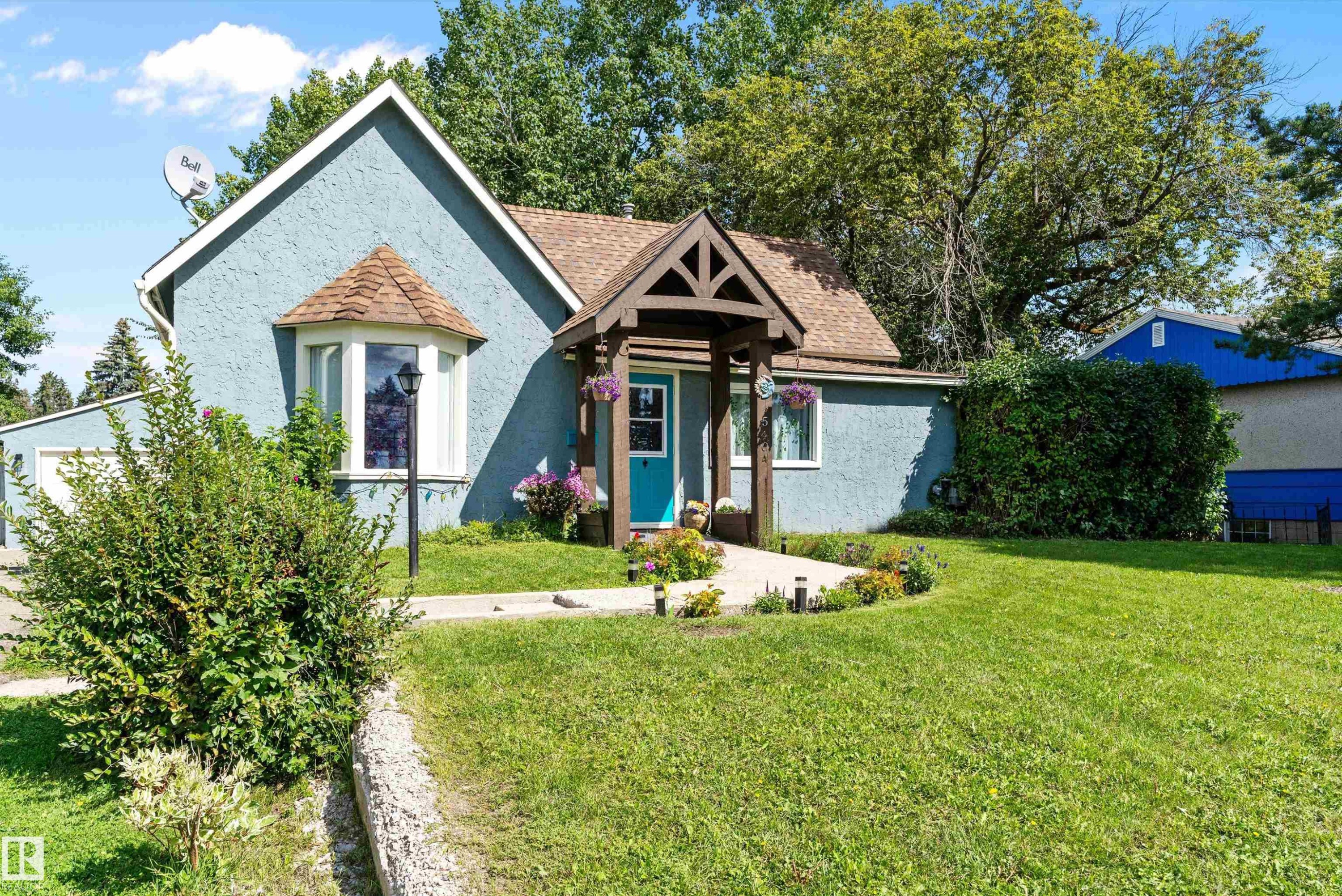 Stucco exterior, gabled roof, covered entry with wood detailing, bay window, landscaped front yard - 5404 45 Avenue, Wetaskiwin, AB - Outdoor