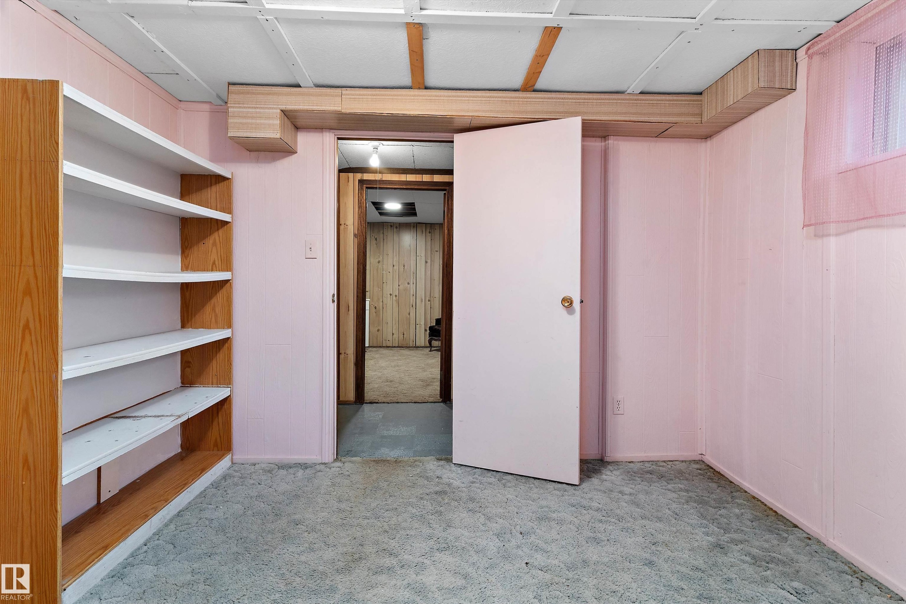 Built-in shelving unit with multiple tiers, textured carpeting, and a drop ceiling - 5404 45 Avenue, Wetaskiwin, AB - Indoor