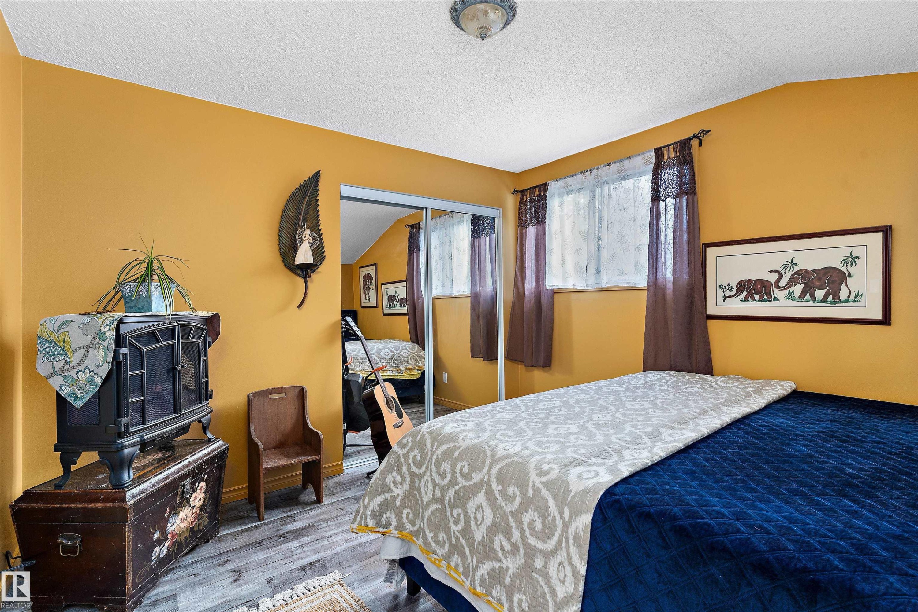 Wood-finish flooring, mirrored sliding closet doors, and recessed window - 5404 45 Avenue, Wetaskiwin, AB - Indoor Photo Showing Bedroom