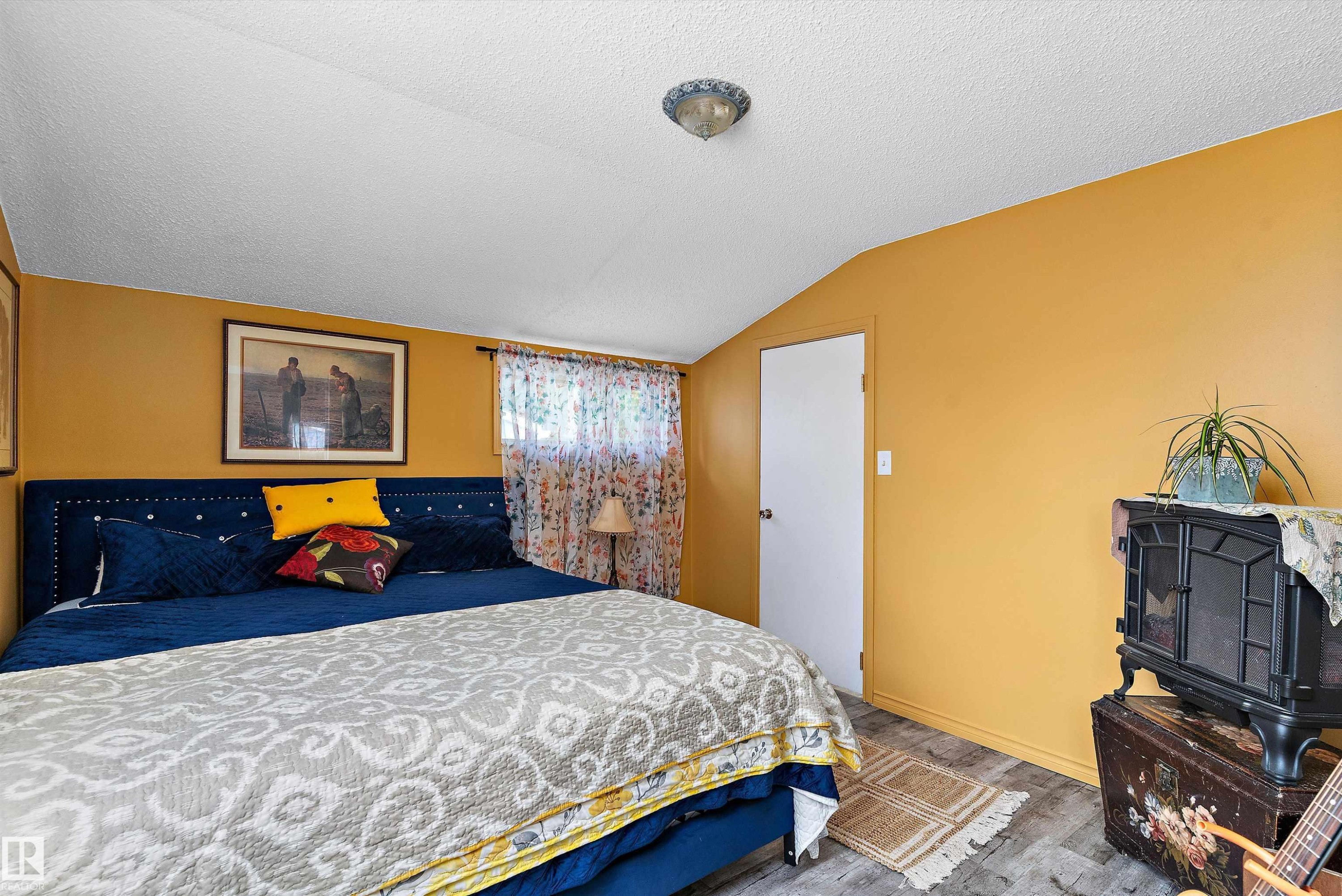 Angled ceiling line with a flush mount light fixture - 5404 45 Avenue, Wetaskiwin, AB - Indoor Photo Showing Bedroom