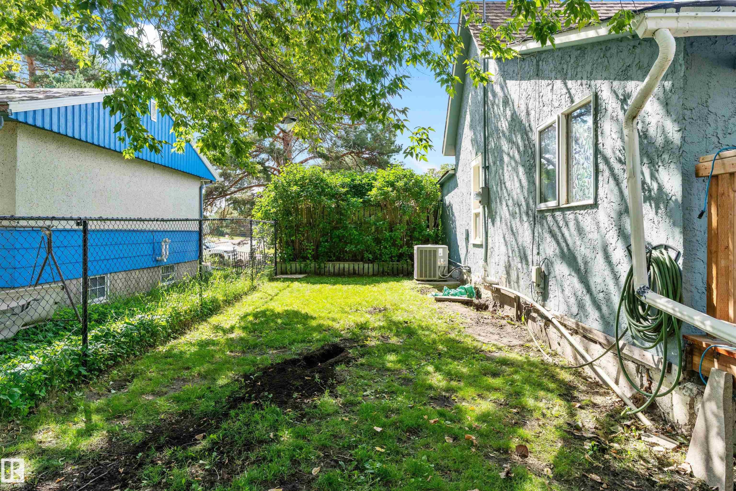 Expansive rear yard featuring green space, mature trees, and a chain link fence - 5404 45 Avenue, Wetaskiwin, AB - Outdoor
