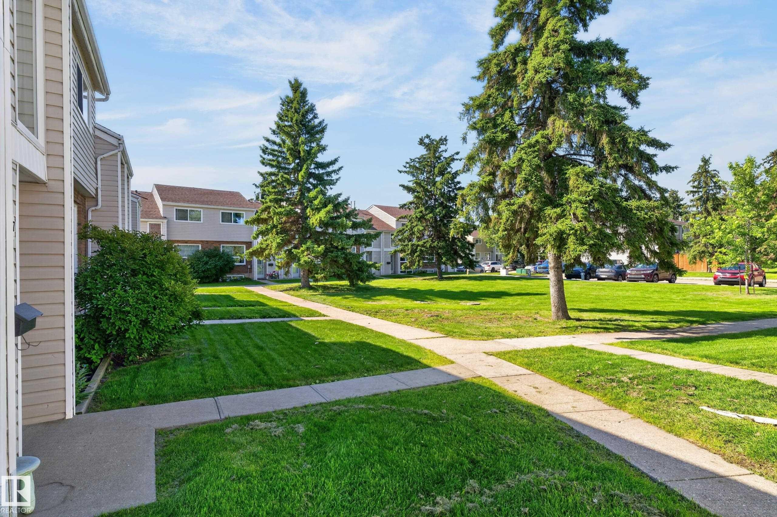Manicured lawn with mature trees and concrete pathways - 18247 93 Avenue Nw, Edmonton, AB - Outdoor