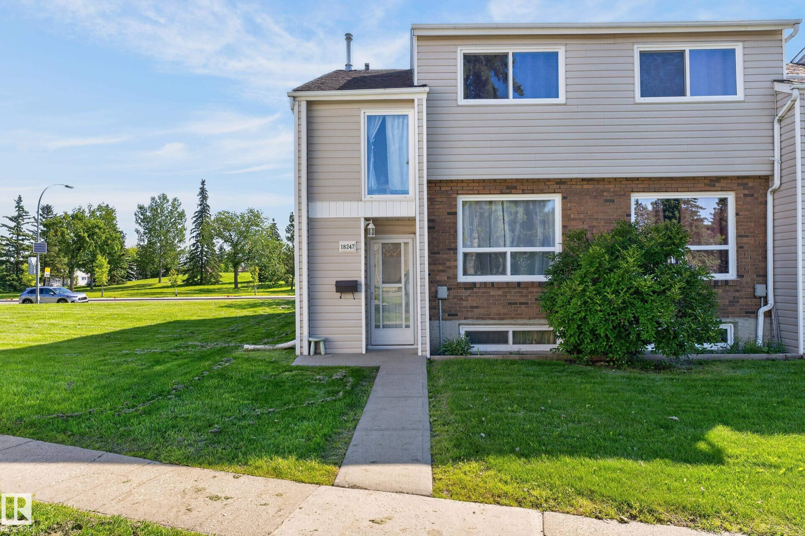Multi-level residence featuring brick and siding exterior, multiple windows, and a concrete pathway - 18247 93 Avenue Nw, Edmonton, AB - Outdoor