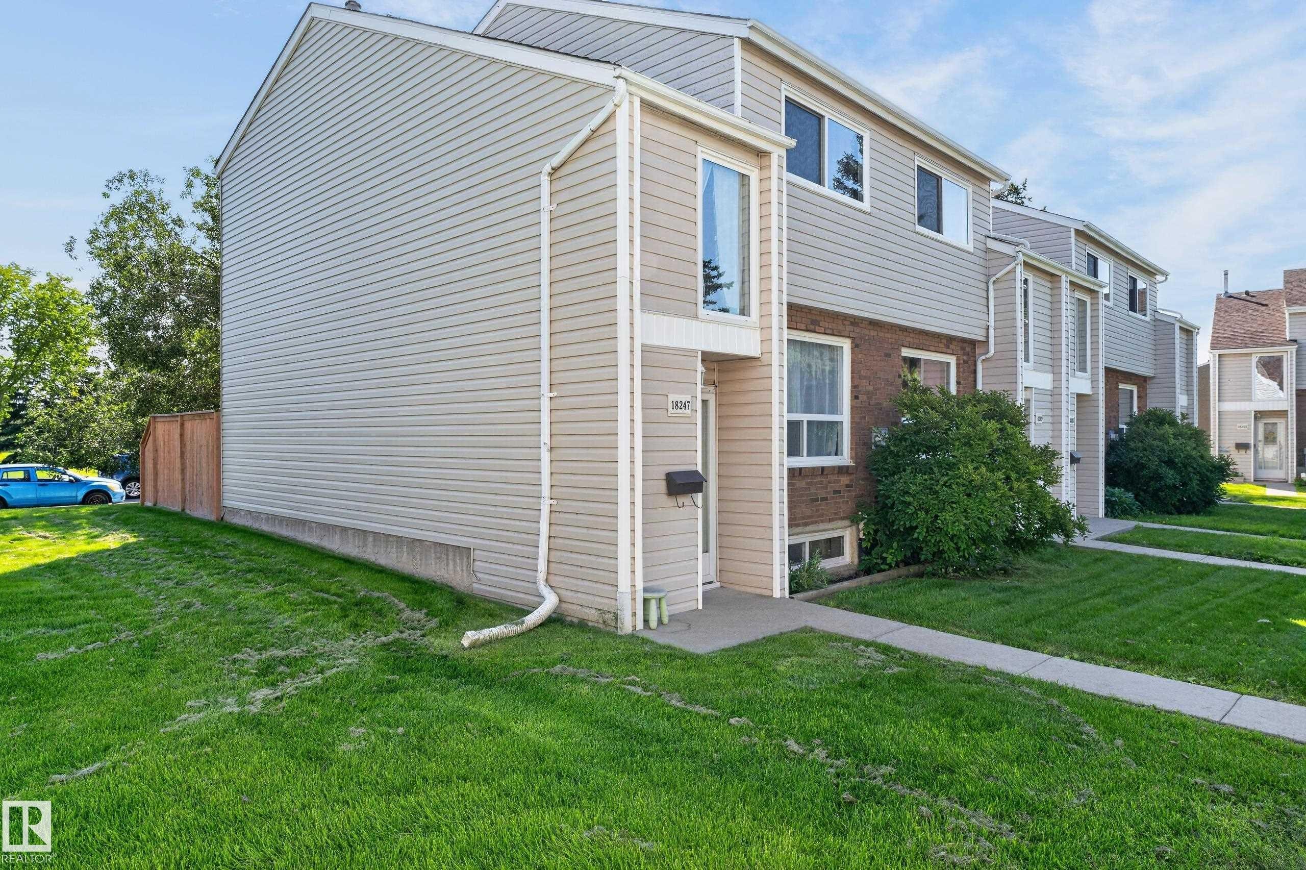 Two-story exterior with horizontal siding, brick accents, a gabled roofline, and a concrete pathway leading to the entry - 18247 93 Avenue Nw, Edmonton, AB - Outdoor