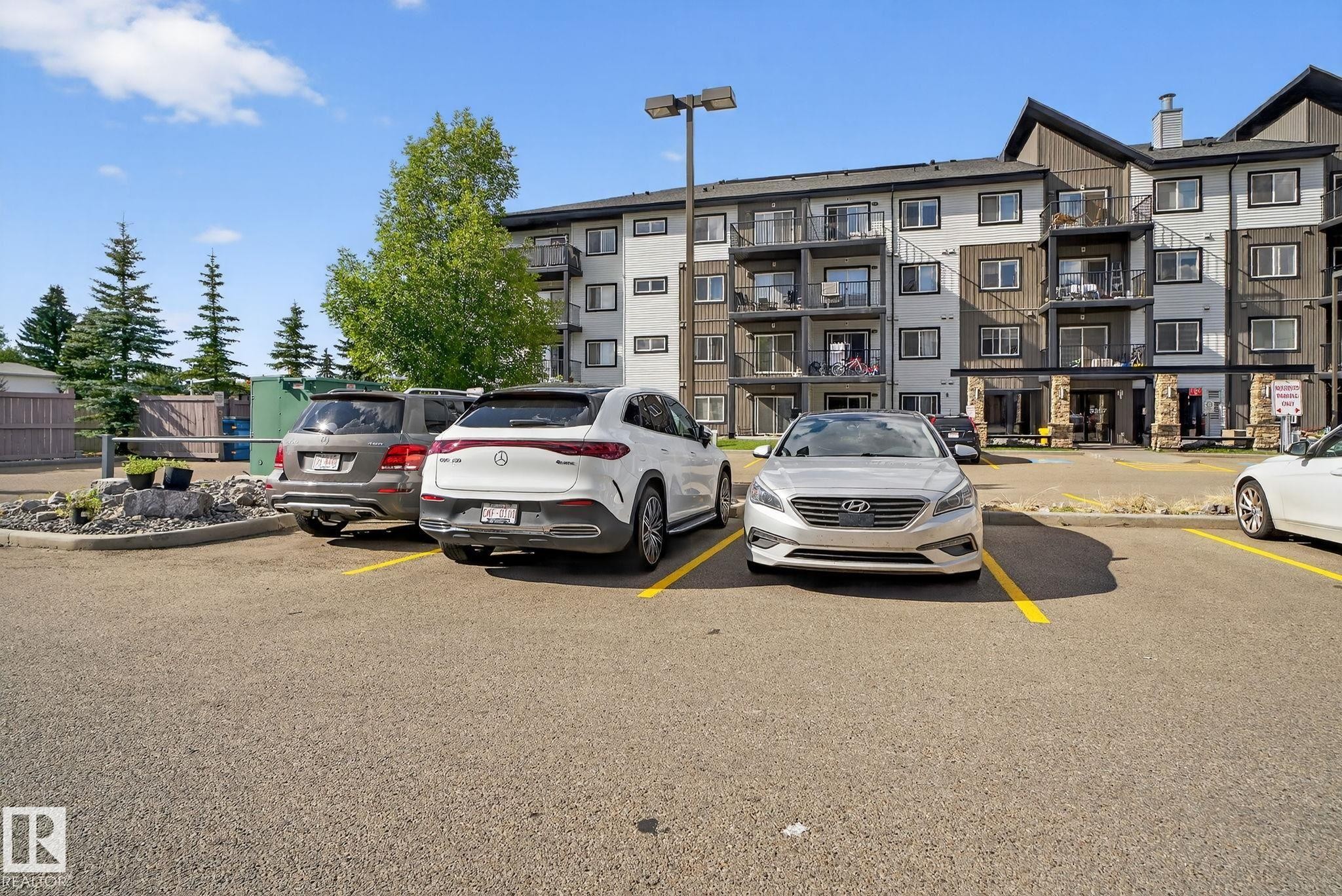 Multi-story building featuring balconies and a stone facade entrance - 3353 16A Avenue Nw, Edmonton, AB - Outdoor With Facade
