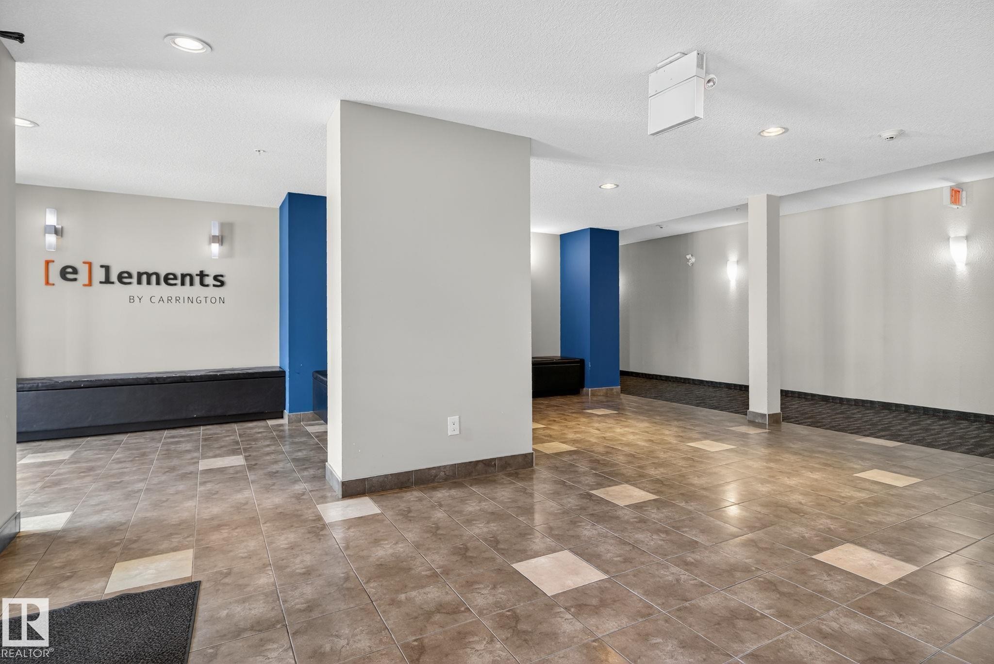 Tiled flooring with contrasting accent squares, built-in black seating, blue accent pillars, recessed lighting, and wall-mounted sconces - 3353 16A Avenue Nw, Edmonton, AB - Indoor Photo Showing Other Room