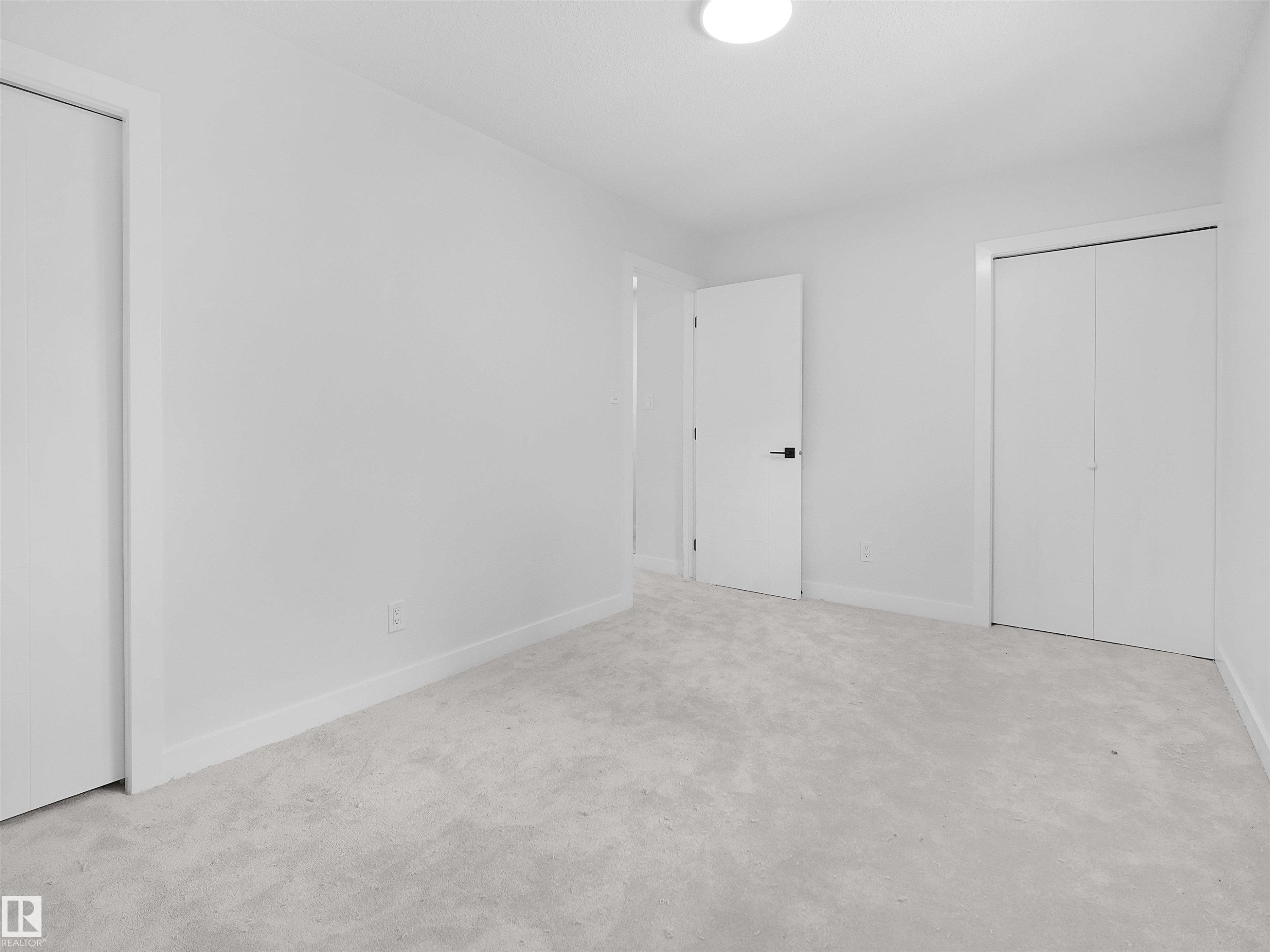 Neutral tone carpeting, white walls, and a flush-mount ceiling light - 126 Woodstock Nw, Edmonton, AB - Indoor Photo Showing Other Room