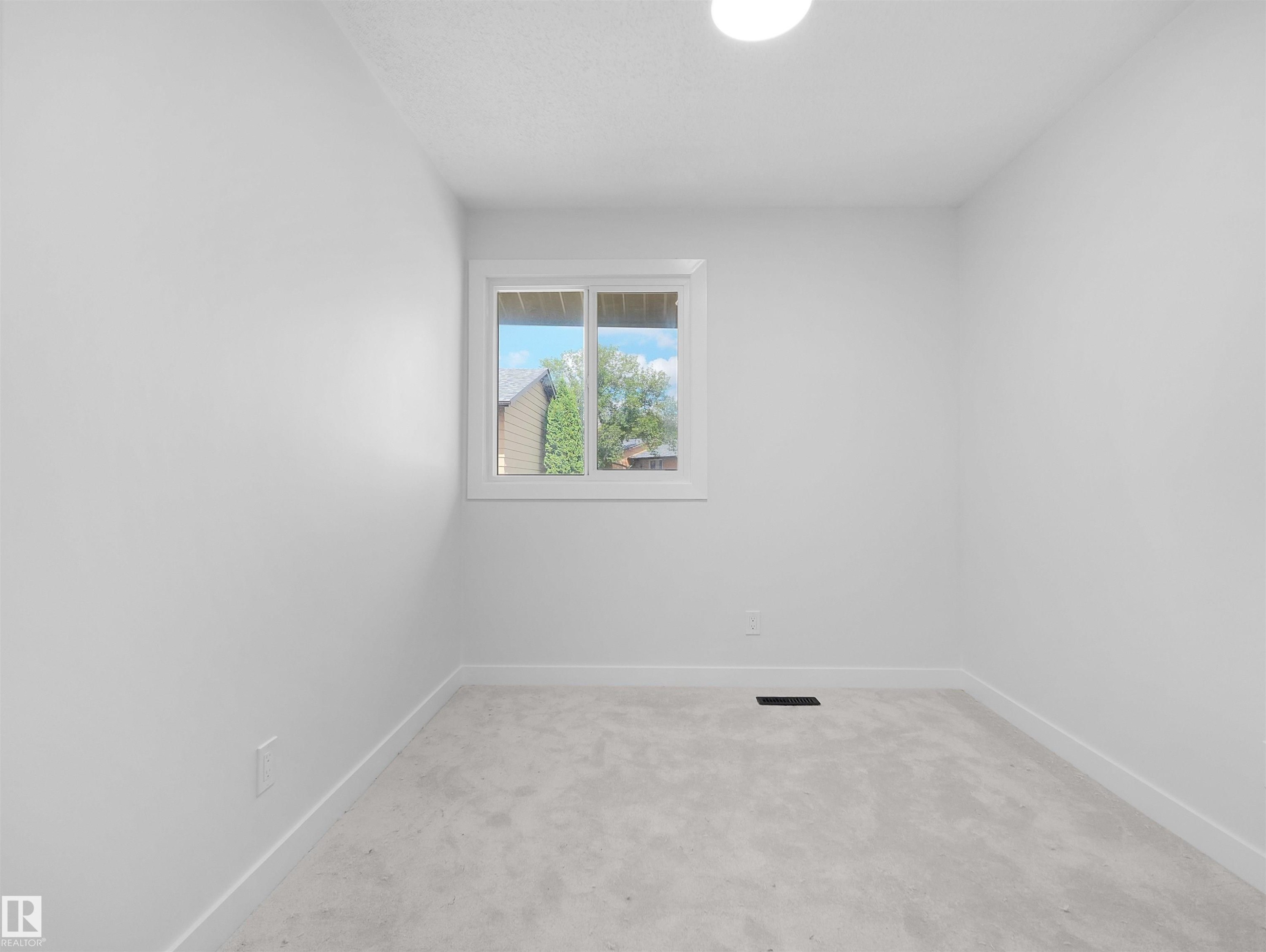 Recessed ceiling light fixture, white walls, white window trim, light grey carpeting, and white baseboards - 126 Woodstock Nw, Edmonton, AB - Indoor Photo Showing Other Room