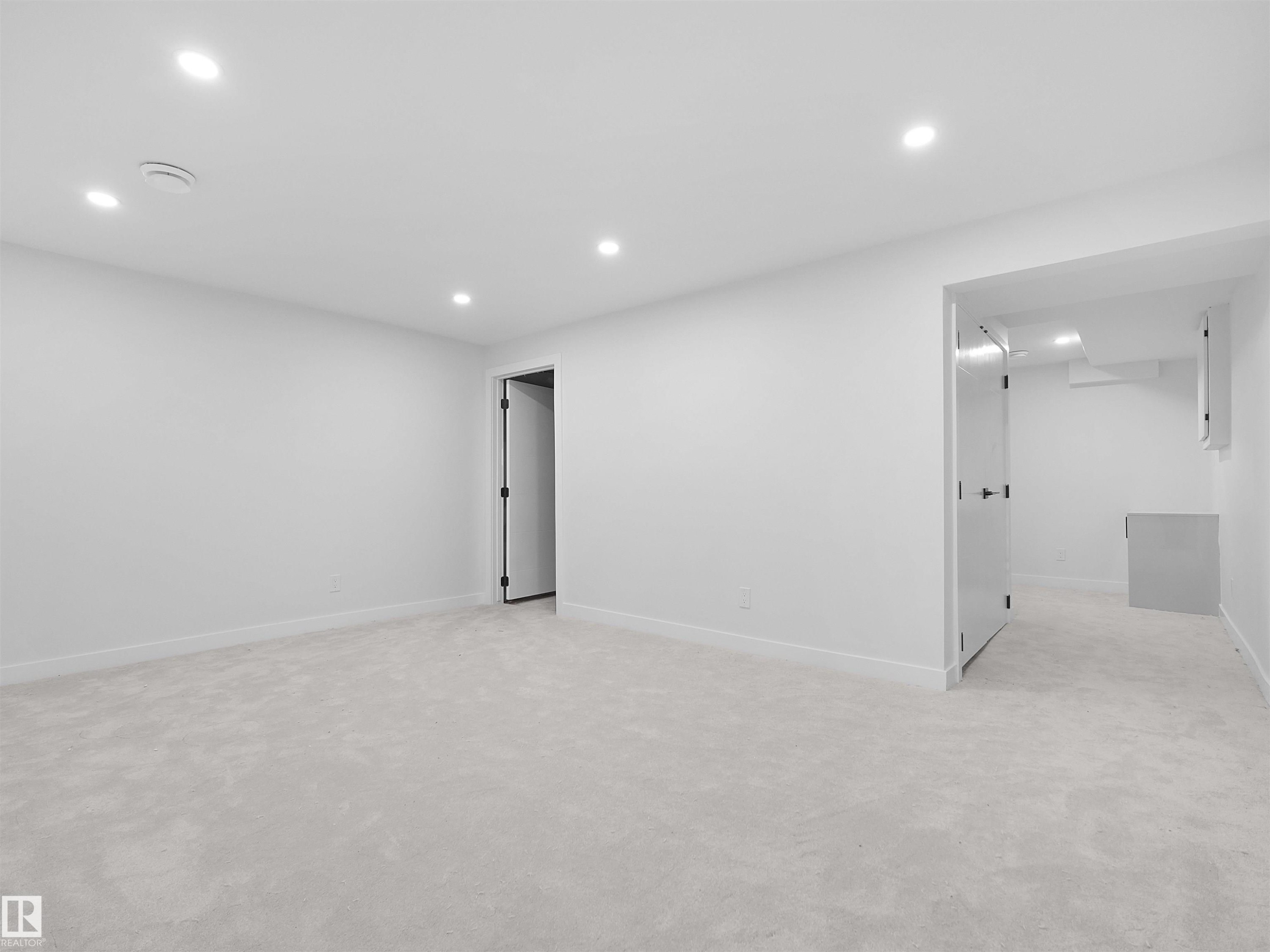 Recessed lighting illuminates this bright room featuring light-toned carpeting and white wall finishes - 126 Woodstock Nw, Edmonton, AB - Indoor