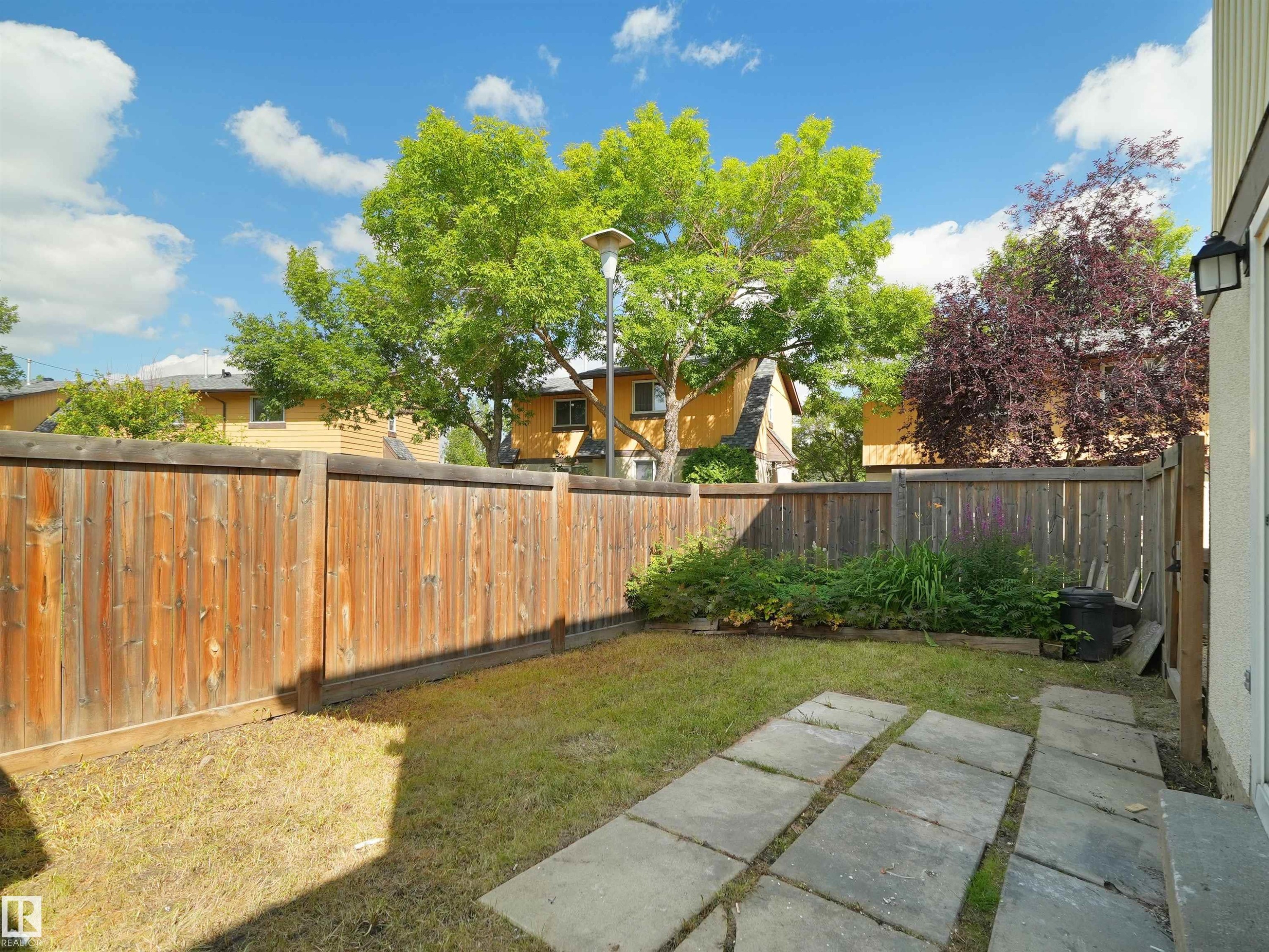 Private fenced yard with established landscaping and paver stone patio - 126 Woodstock Nw, Edmonton, AB - Outdoor With Backyard