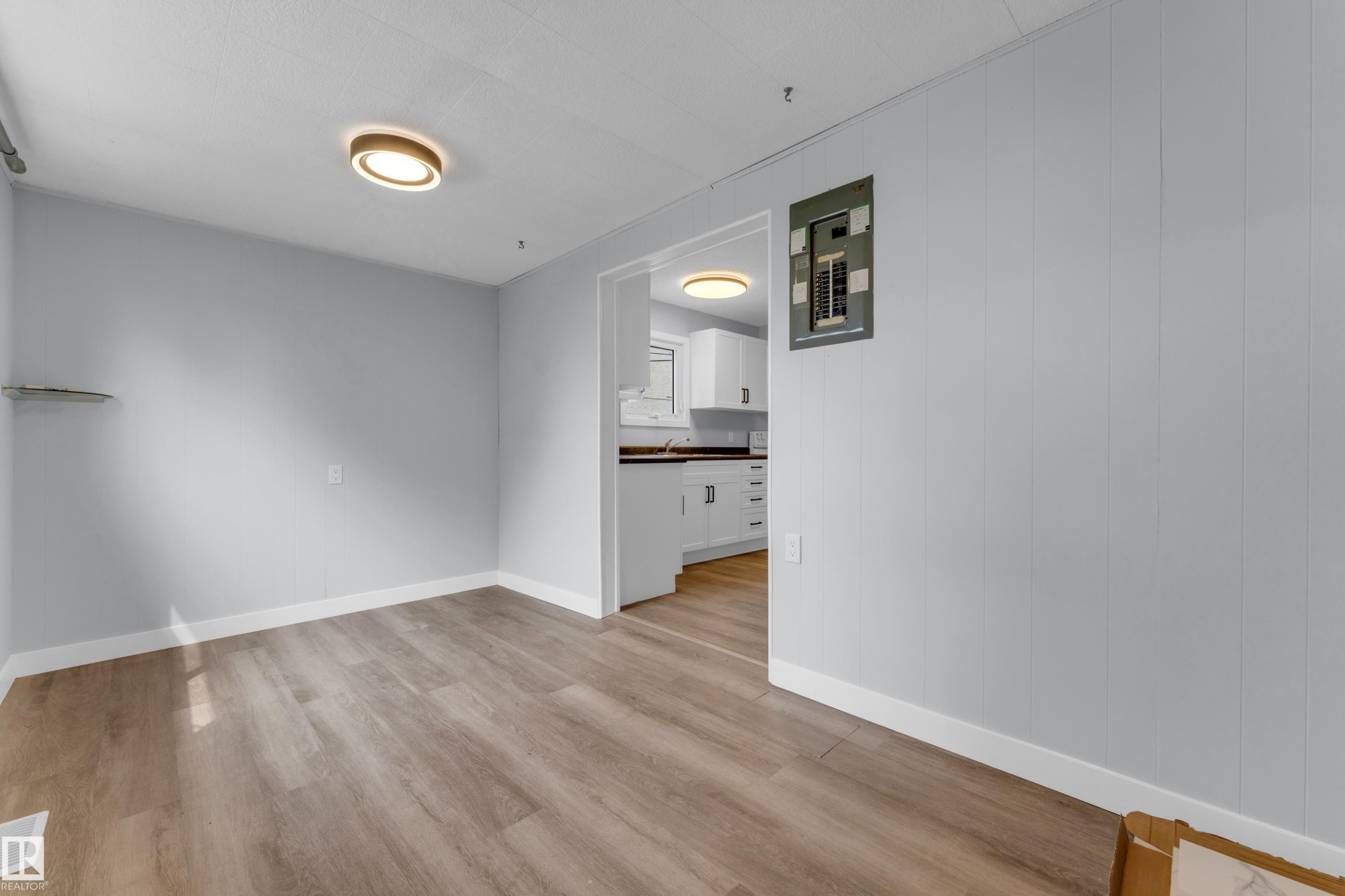 Open-plan area featuring wood-finish flooring, light gray wall paint, and recessed lighting fixtures - 9416 153 Street Nw, Edmonton, AB - Indoor Photo Showing Other Room