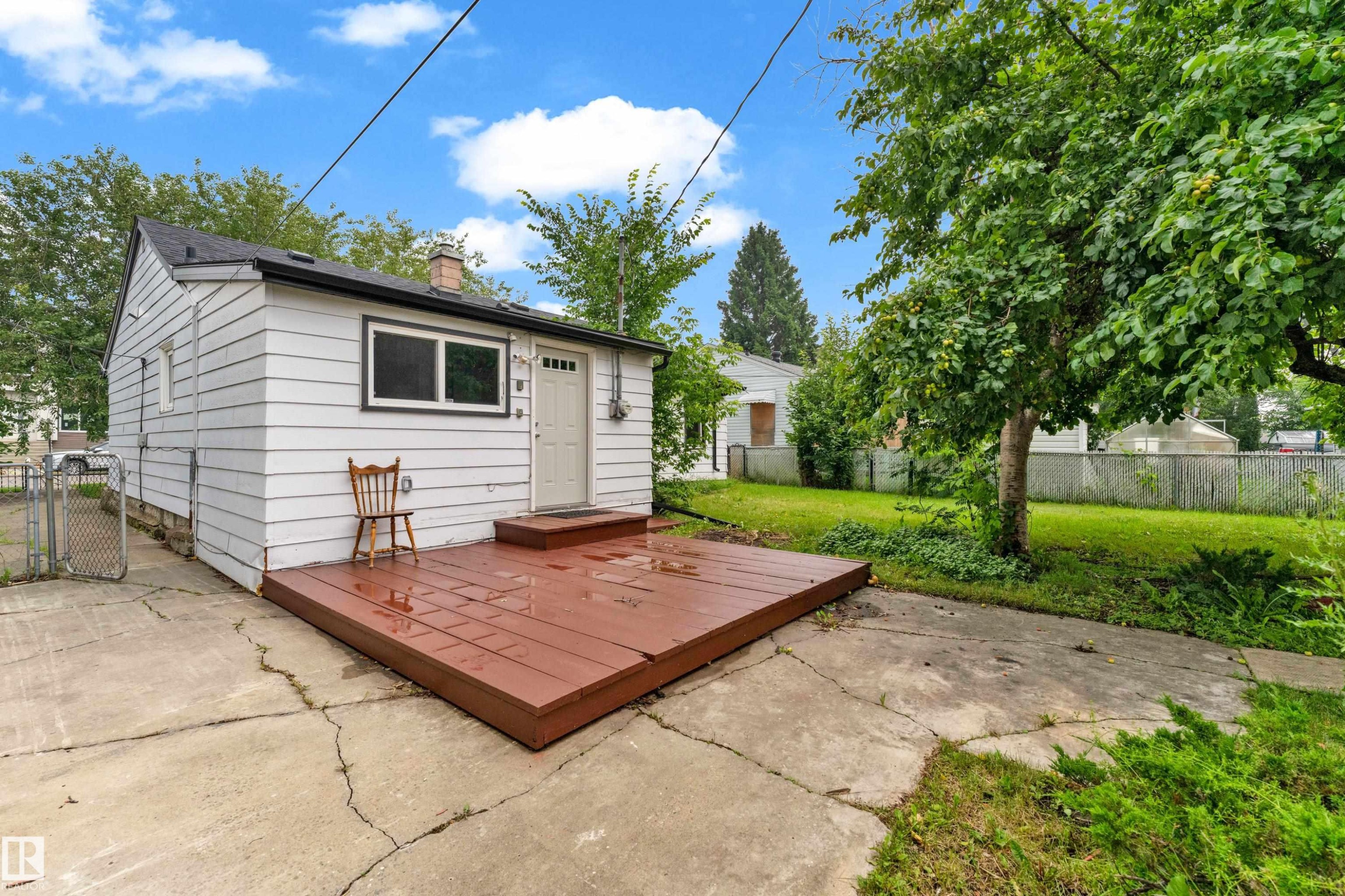 White siding exterior with a dark shingle roof and a brick chimney - 9416 153 Street Nw, Edmonton, AB - Outdoor