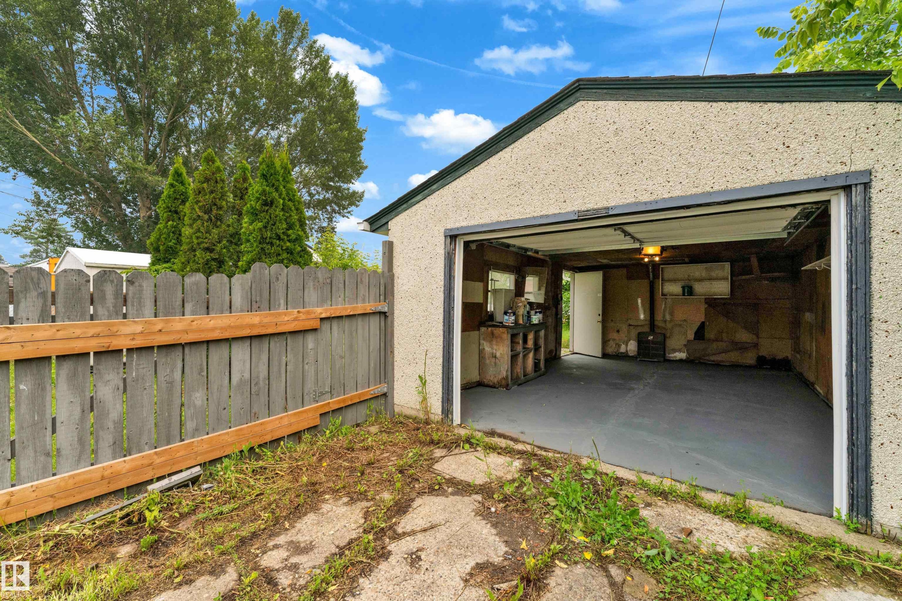 Detached single-car garage featuring a stucco exterior and open overhead door - 9416 153 Street Nw, Edmonton, AB - Outdoor