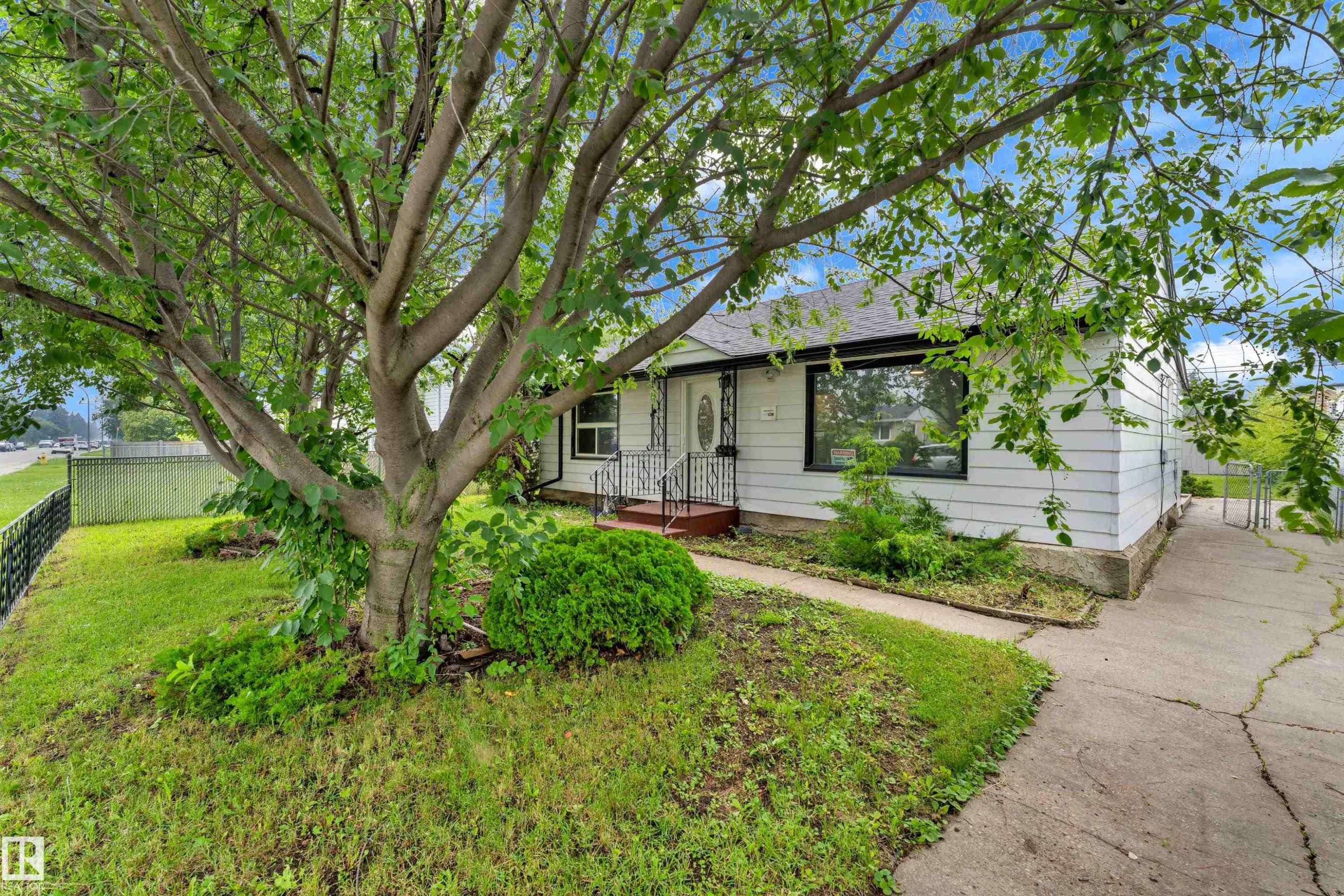 Front exterior featuring white siding, black trim windows, and a dark shingle roof - 9416 153 Street Nw, Edmonton, AB - Outdoor