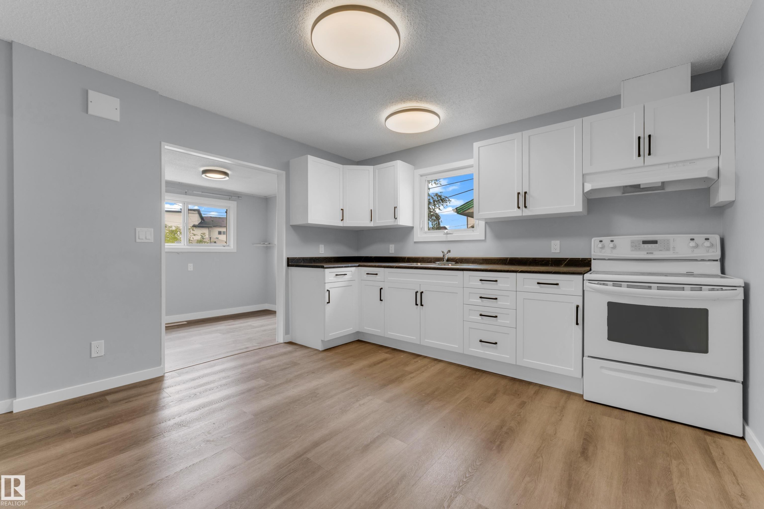 Kitchen featuring white cabinetry, dark countertops, a built-in range, wood-finish flooring, and recessed lighting - 9416 153 Street Nw, Edmonton, AB - Indoor Photo Showing Kitchen
