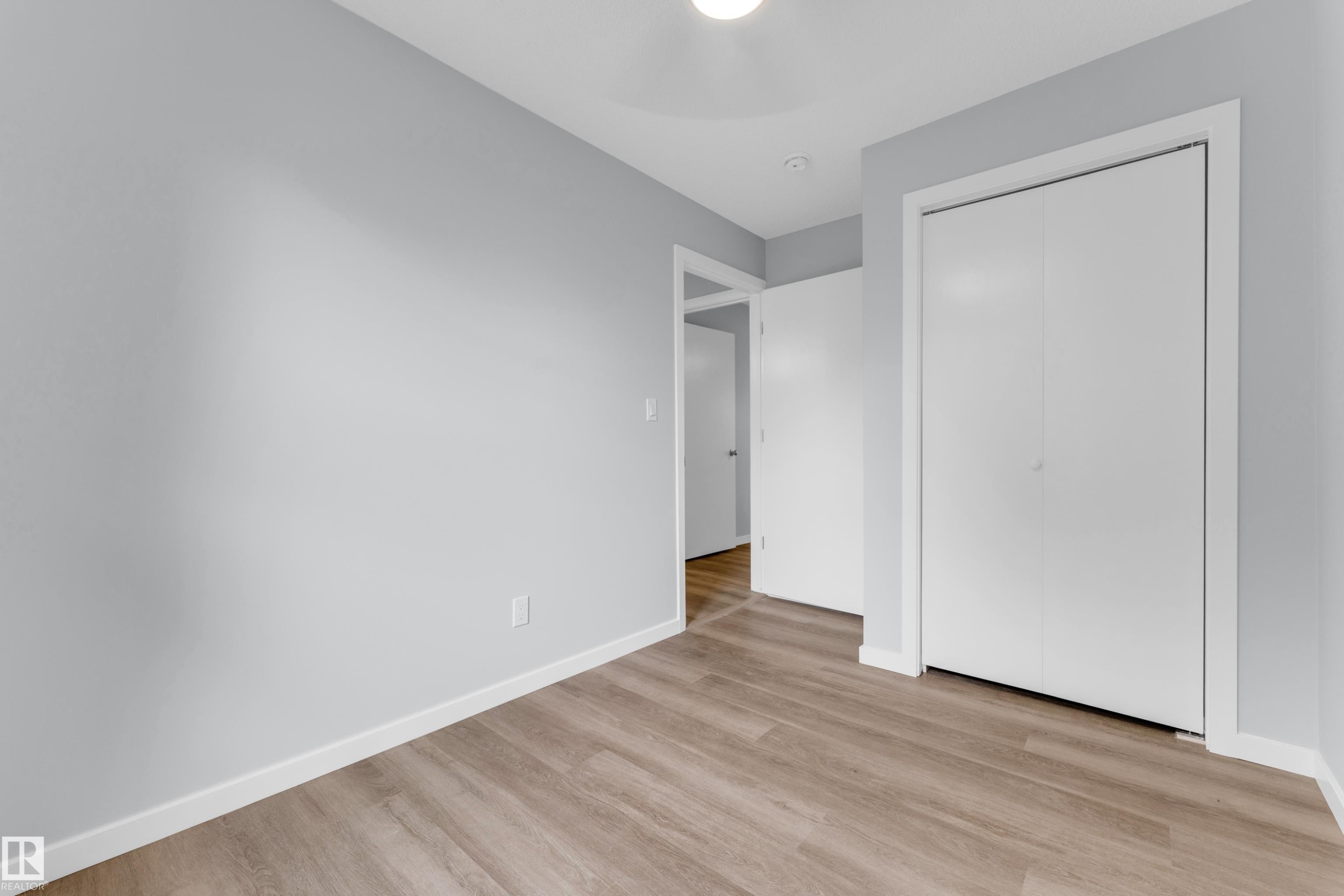 Room featuring wood-finish flooring, light gray wall paint, and white trim - 9416 153 Street Nw, Edmonton, AB - Indoor Photo Showing Other Room
