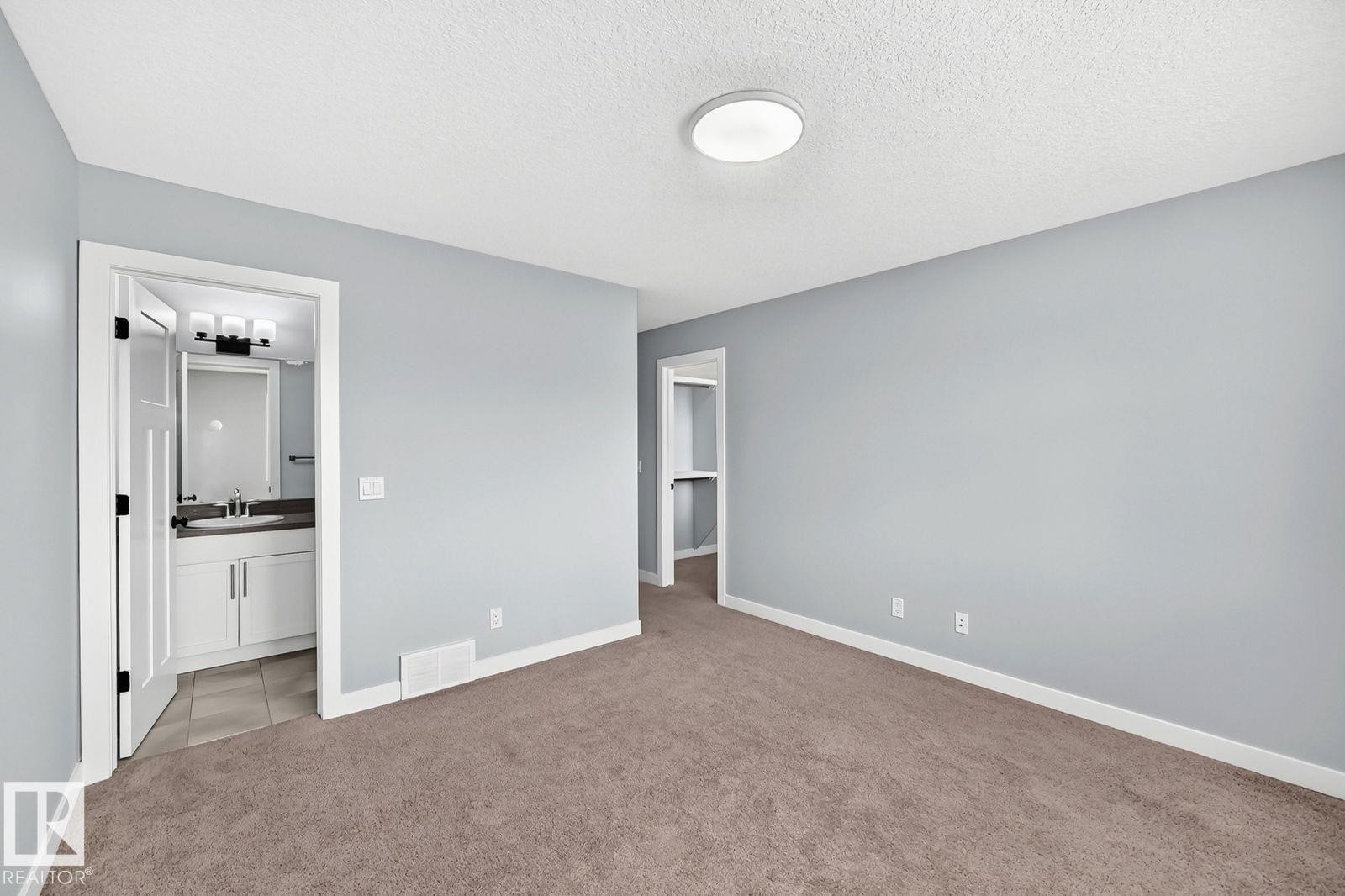 Light gray wall paint, textured ceiling, flush mount ceiling light, light brown carpeting, white trim - 1112 176 Street Sw, Edmonton, AB - Indoor Photo Showing Other Room