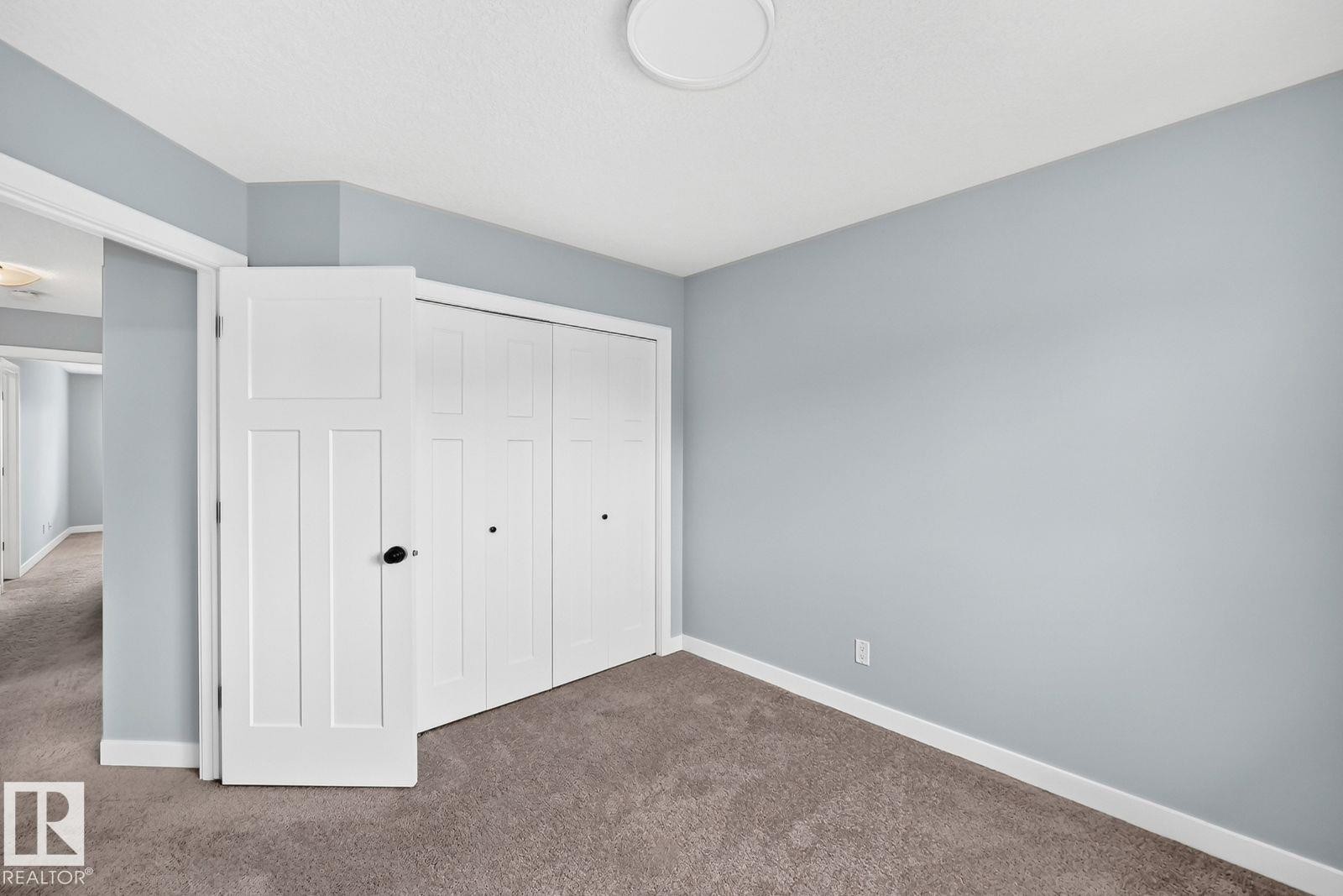 Carpet flooring and a flush-mount ceiling light - 1112 176 Street Sw, Edmonton, AB - Indoor Photo Showing Other Room