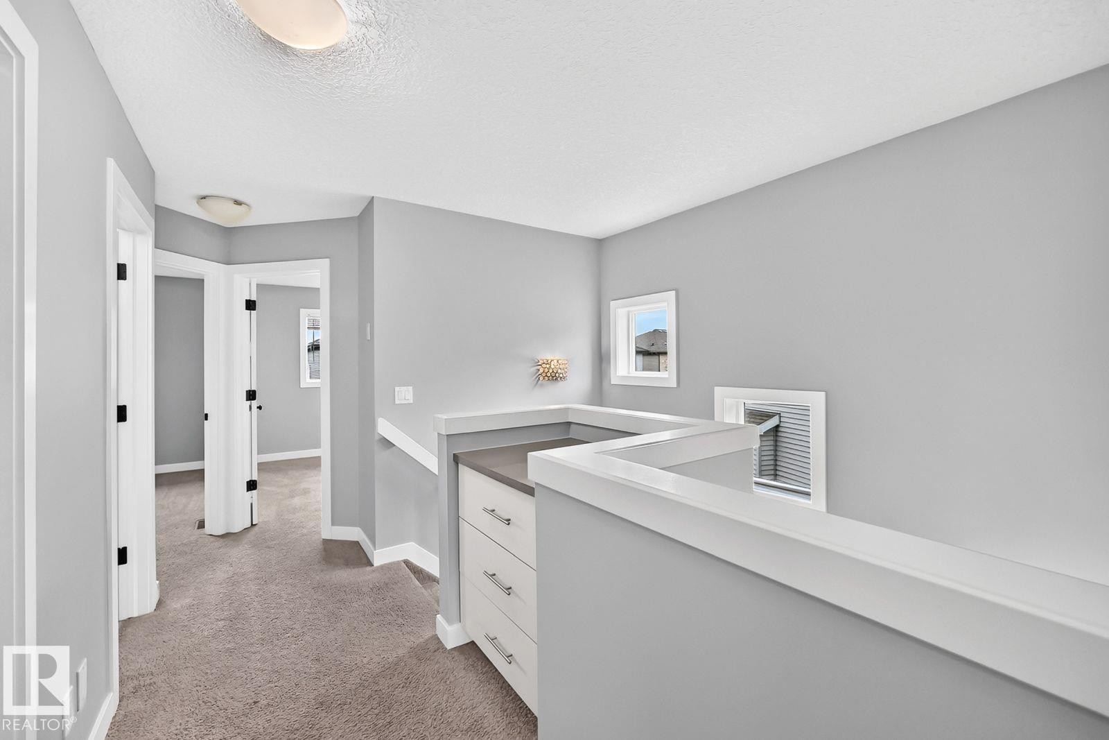 Hallway with gray carpeting, white trim, and light gray walls - 1112 176 Street Sw, Edmonton, AB - Indoor